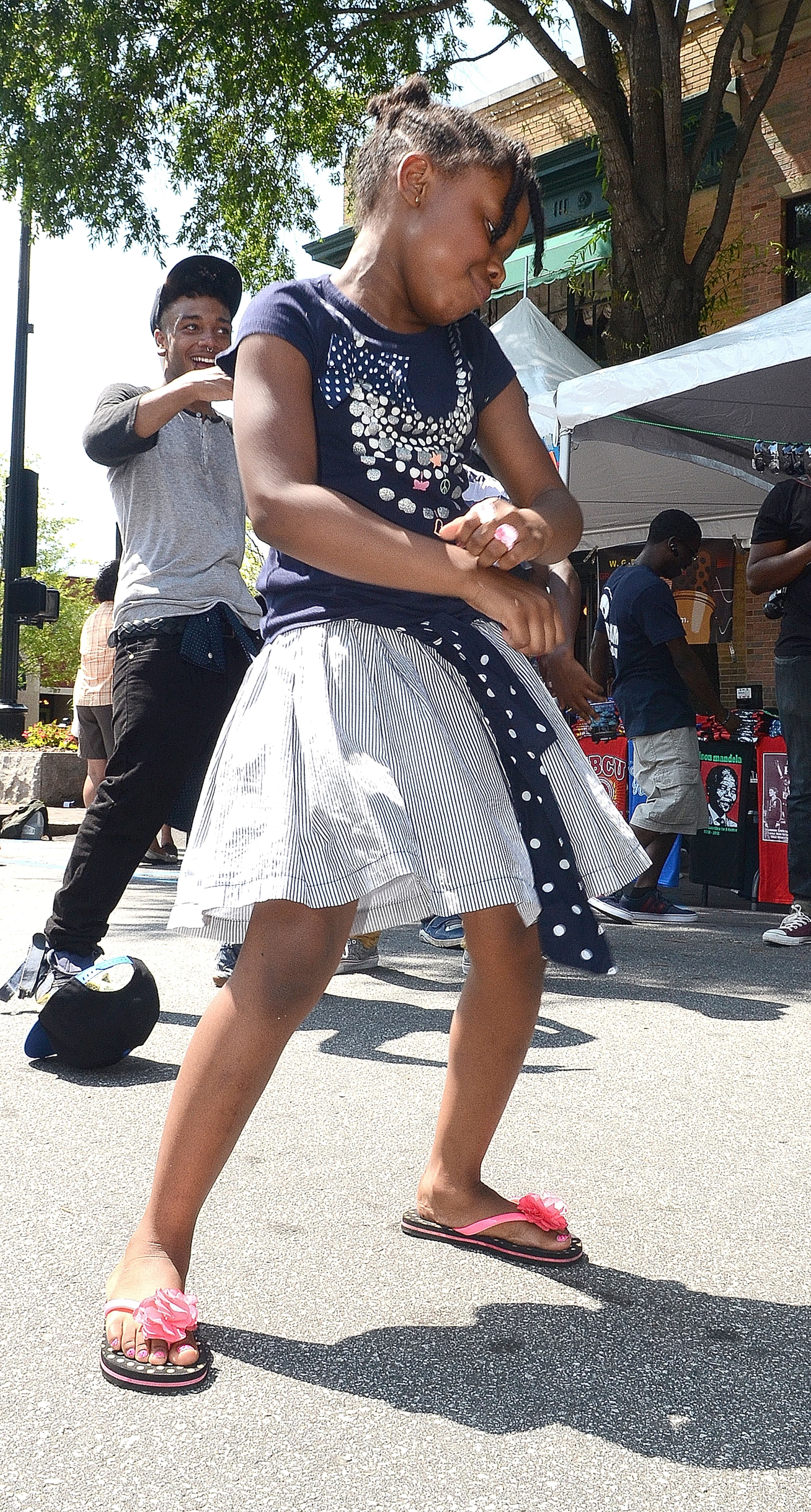 With a little background help from the dance performers UniqueSouls, Aniya Griffin, 8 of Marietta, performs a crowd-pleasing impromptu street dance at the 11th Annual Juneteenth Cultural Festival, cultural event, health fair with entertainment, food, vendors, fellowship and a community of more than 35,000 people enjoying the festivities. Juneteenth is hosted by the Cobb County Branch of the NAACP. The Juneteenth Celebration is a cultural festival that celebrates Juneteenth, the name given to the date June 19, 1865 commemorating the date that the last United States slaves were freed. (PHOTO M. CHRIS HUNT)