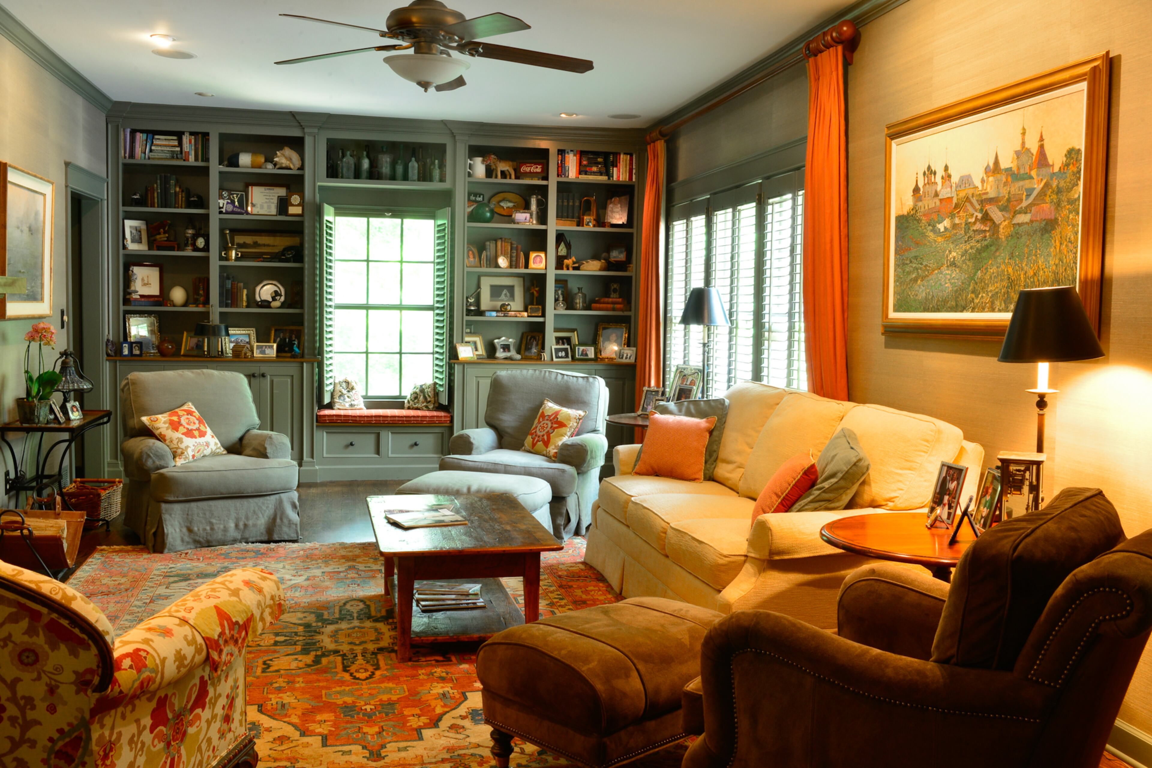 A darker palette with Sherwin-Williams' Link Gray for the bookshelves and trim gives the family room a more masculine feel, said homeowner Lisa Gleim-Jonas. Reinhart Furniture of Woodstock created the built-in bookcases and window seat. The painting of a Russian farm scene, on a grass cloth wall, is among the Russian art collected by the homeowners.