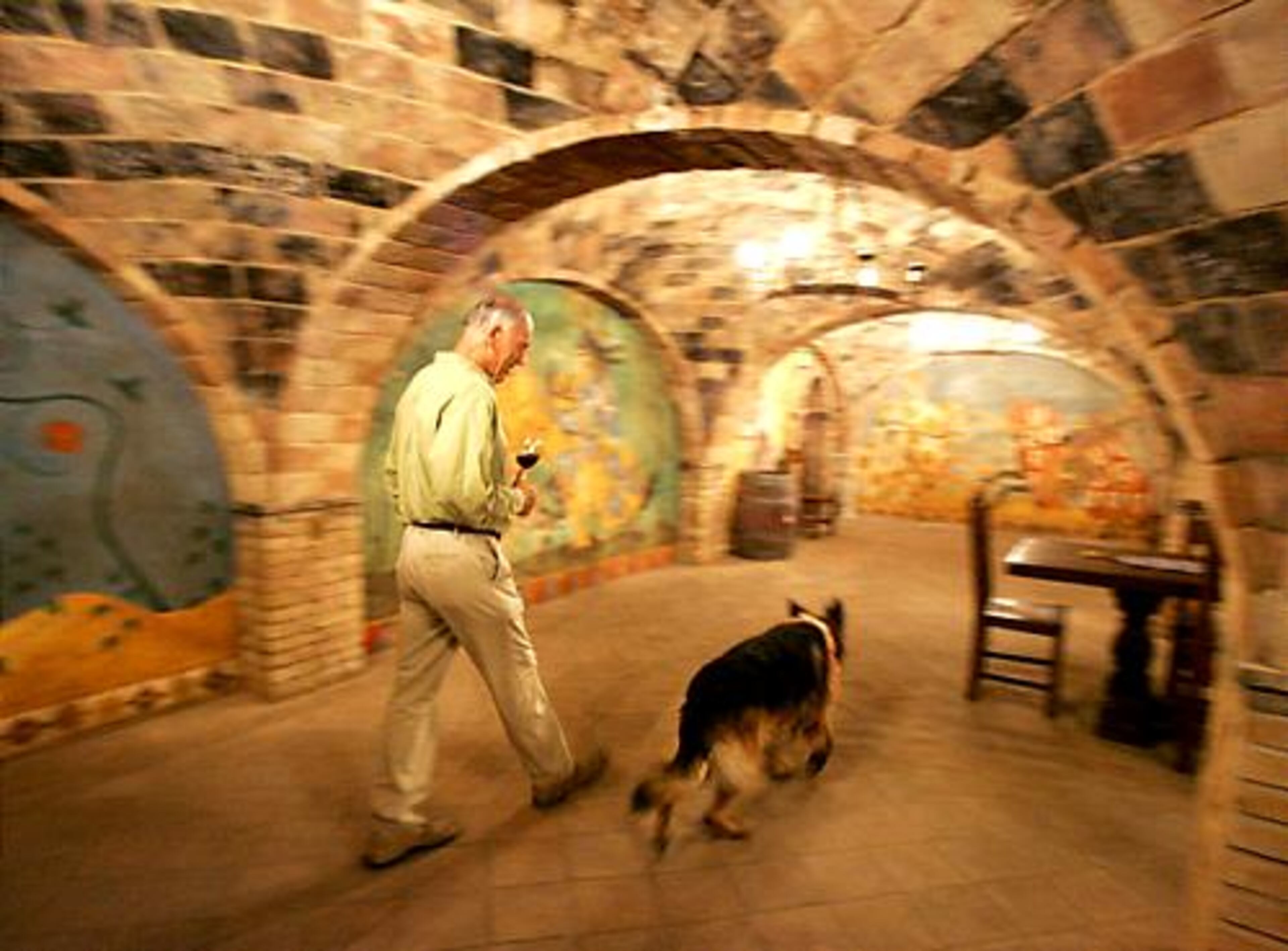 Daryl Sattu walks with his dog through one of the 107 rooms at the Castello di Amorosa in Calistoga, Calif.