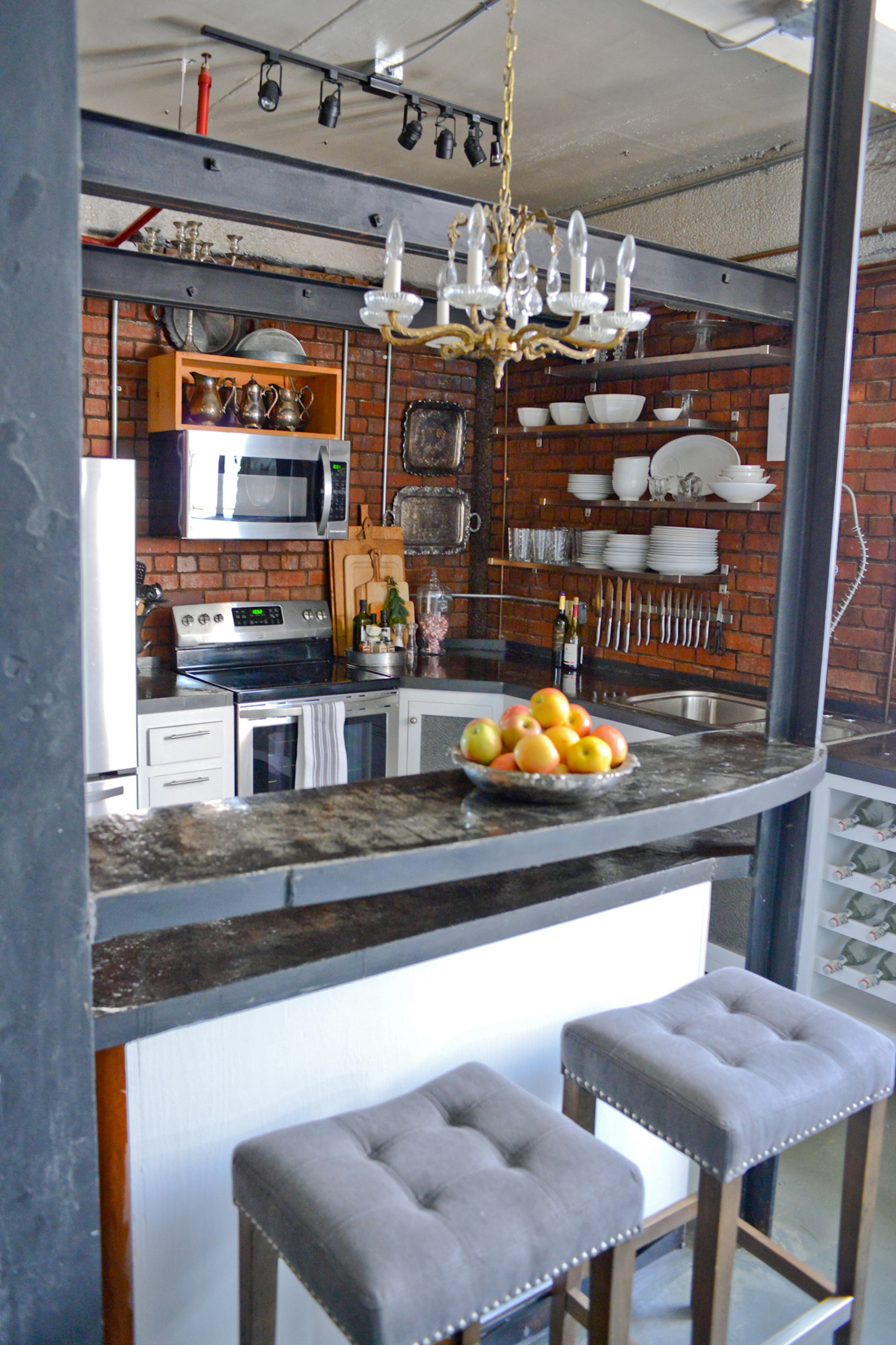 The homeowners kept the original trolley system that was in use when that area of their home contained a factory elevator. Updates include stainless steel appliances, concrete countertops and white cabinets.