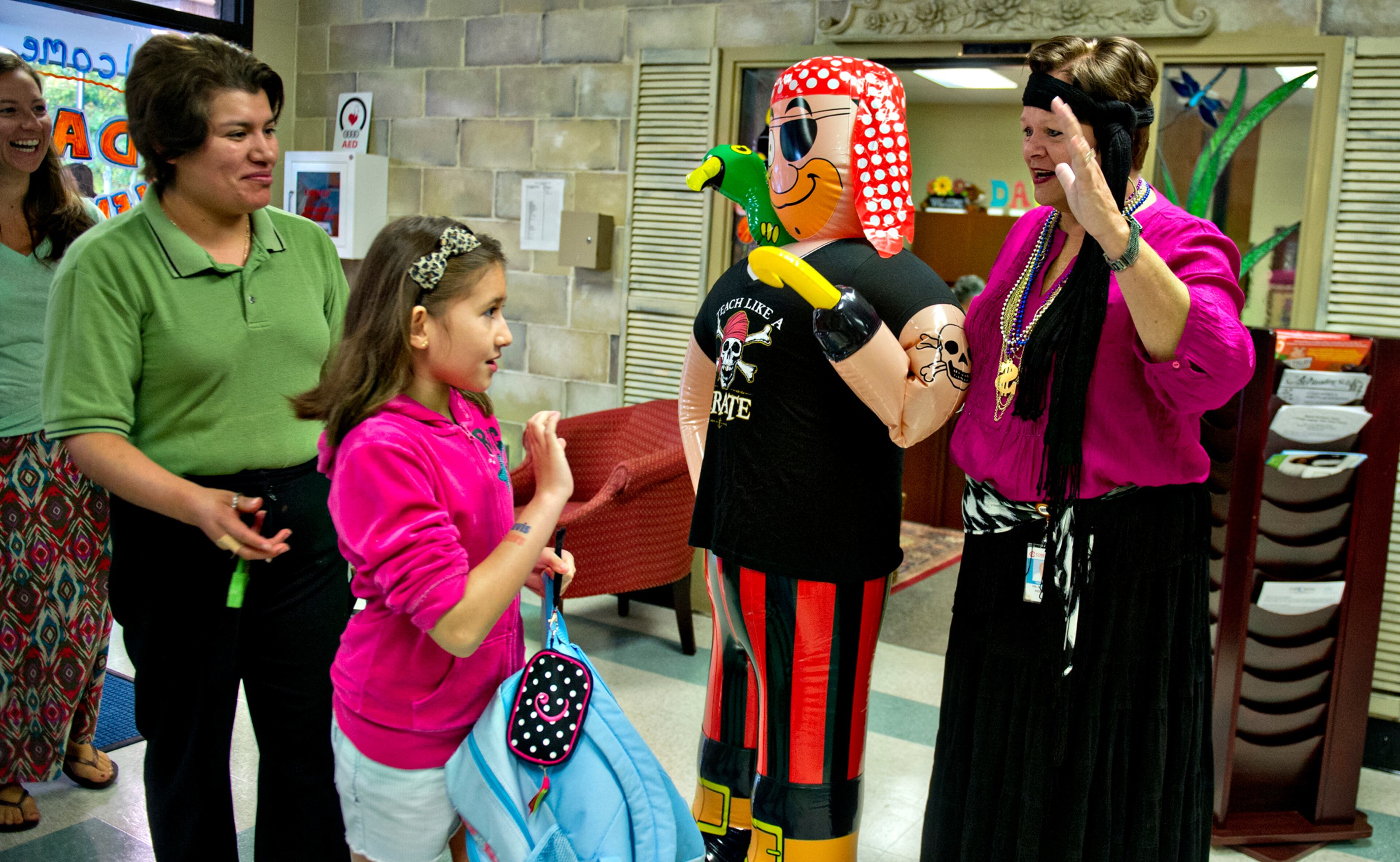 Principal Dr. Dee Mobley (right) waves to Carla Ardelean and her mother Mirely during the first day of classes at Davis Elementary School in Marietta on Monday, August 4, 2014. Teachers and administrators at the school dressed as pirates for the first day of school. Students in Cobb County and Atlanta public schools headed back to class on Monday for the new school year. JONATHAN PHILLIPS / SPECIAL