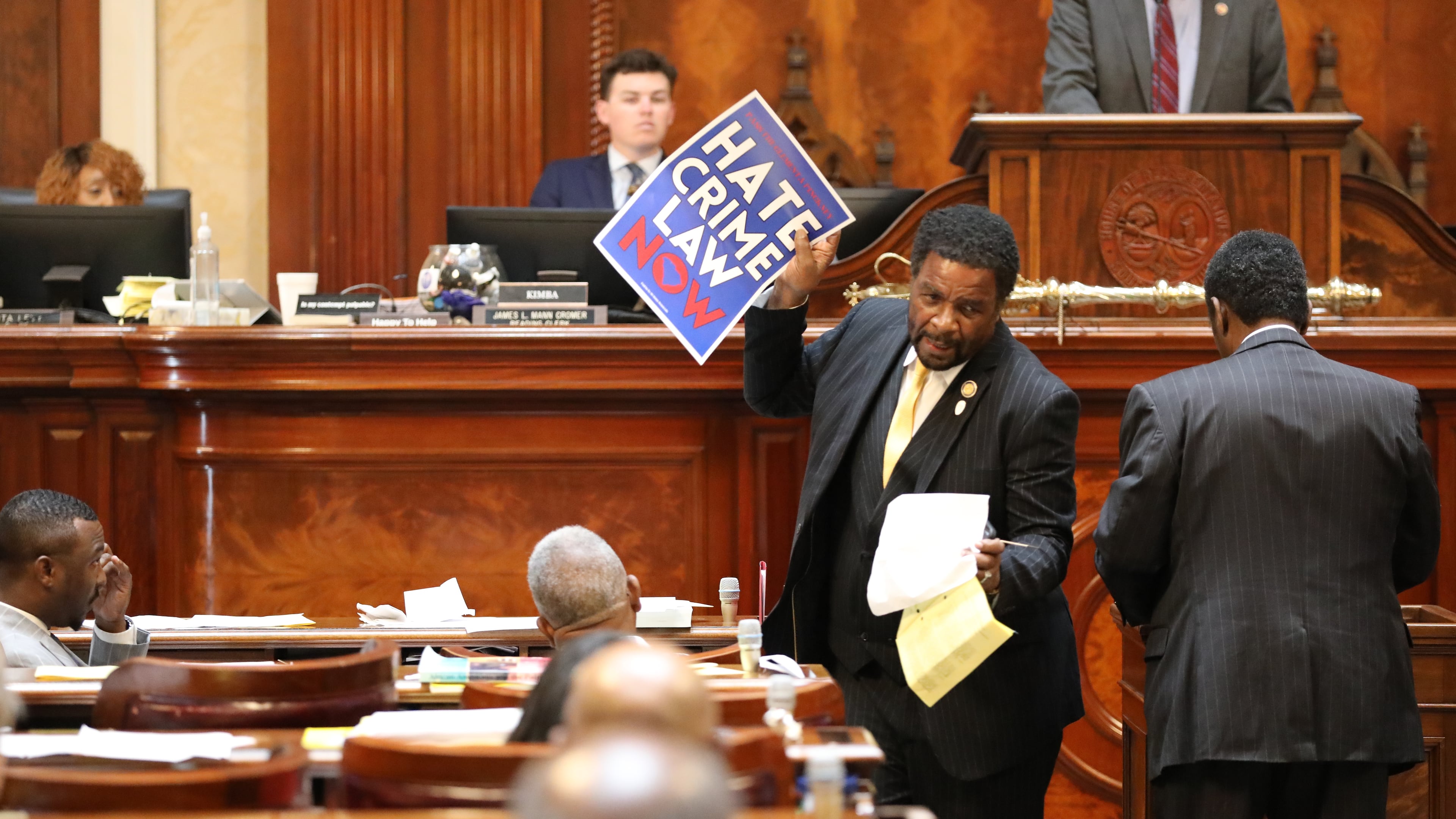 Democratic South Carolina Rep. Wendell Gillard walks back to his desk with a sign after giving a speech during the redistricting debate on Tuesday. May 19, 2026, in Columbia, S.C. (AP Photo/Jeffrey Collins)