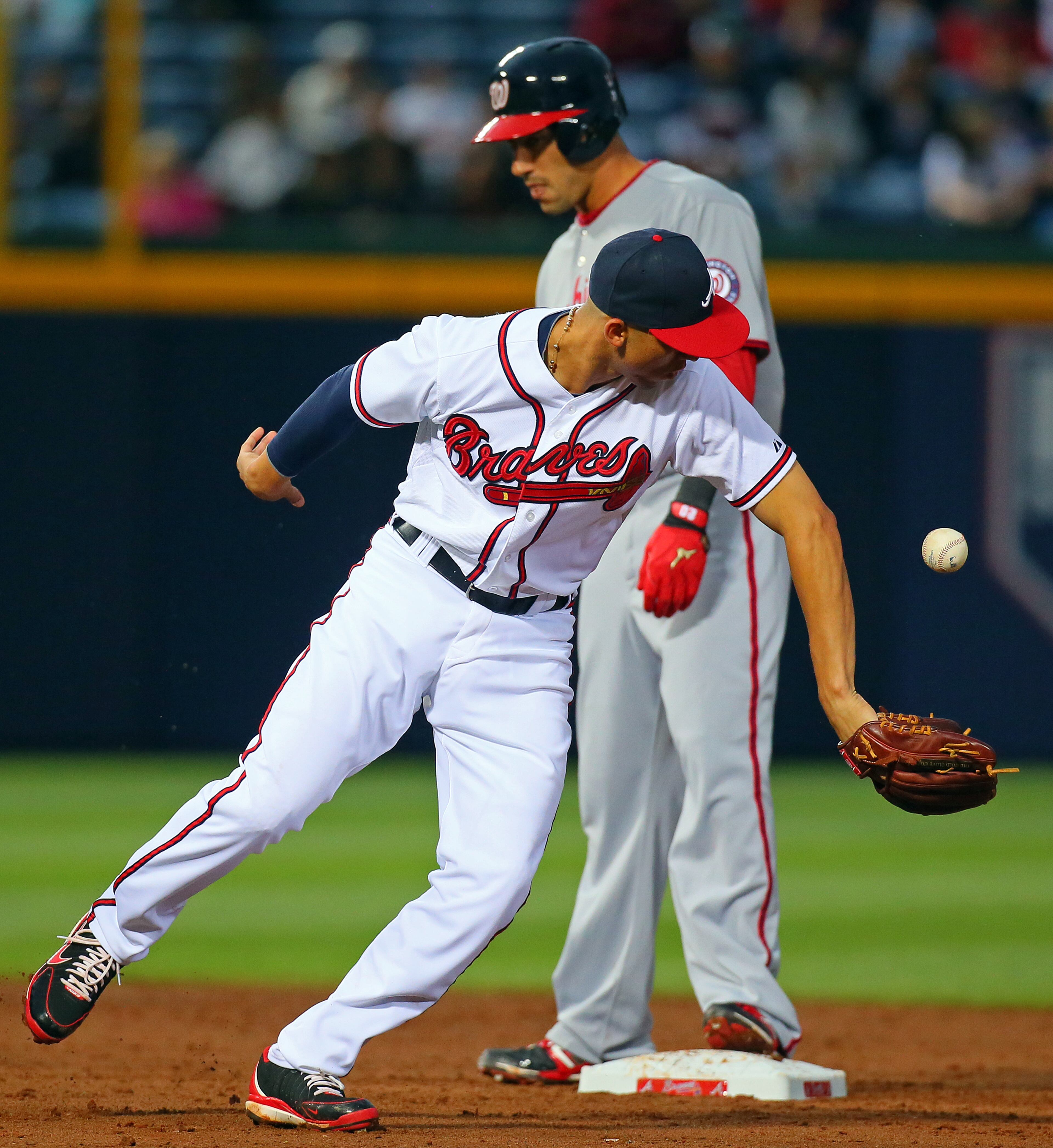 Braves shortstop Andrelton Simmons bobbles the ball as Nationals Ian Desmond gets to second base for a double during the third.