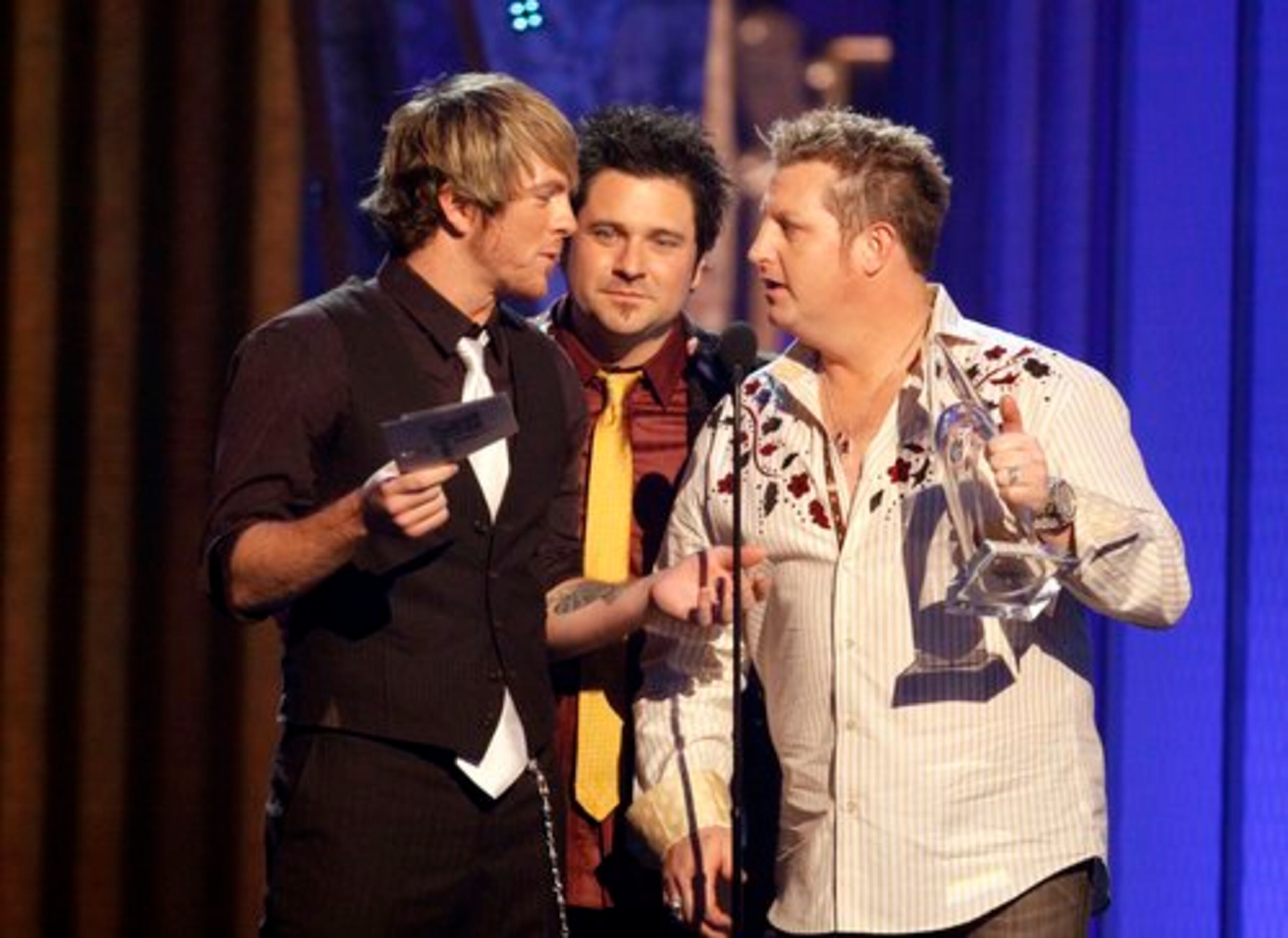 Gary LeVox (from left), Jay DeMarcus and Joe Don Rooney of the band Rascal Flatts accept the Vocal Group of the Year award.