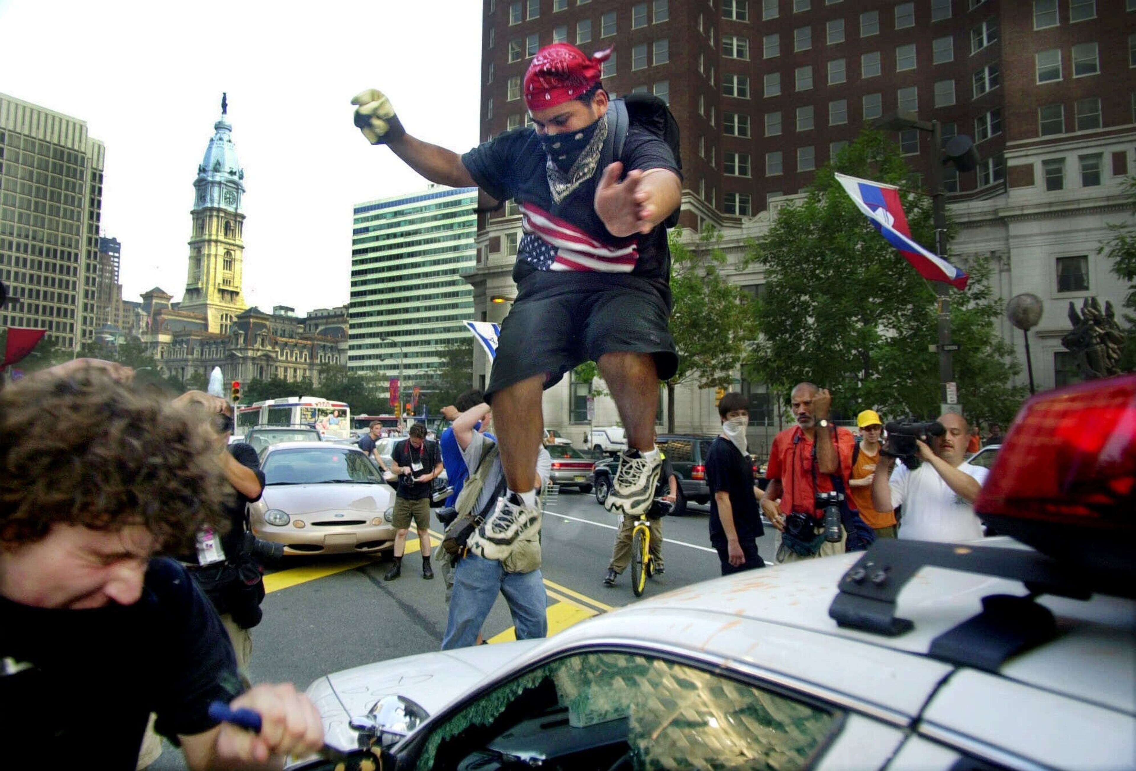 A protester jumps on the windshield of a Philadelphia Police car in downtown Philadelphia, Tuesday, Aug. 1, 2000. Demonstrations were stagged during the Republican National Convention being held in Philadelphia. (AP Photo/Dave Martin)