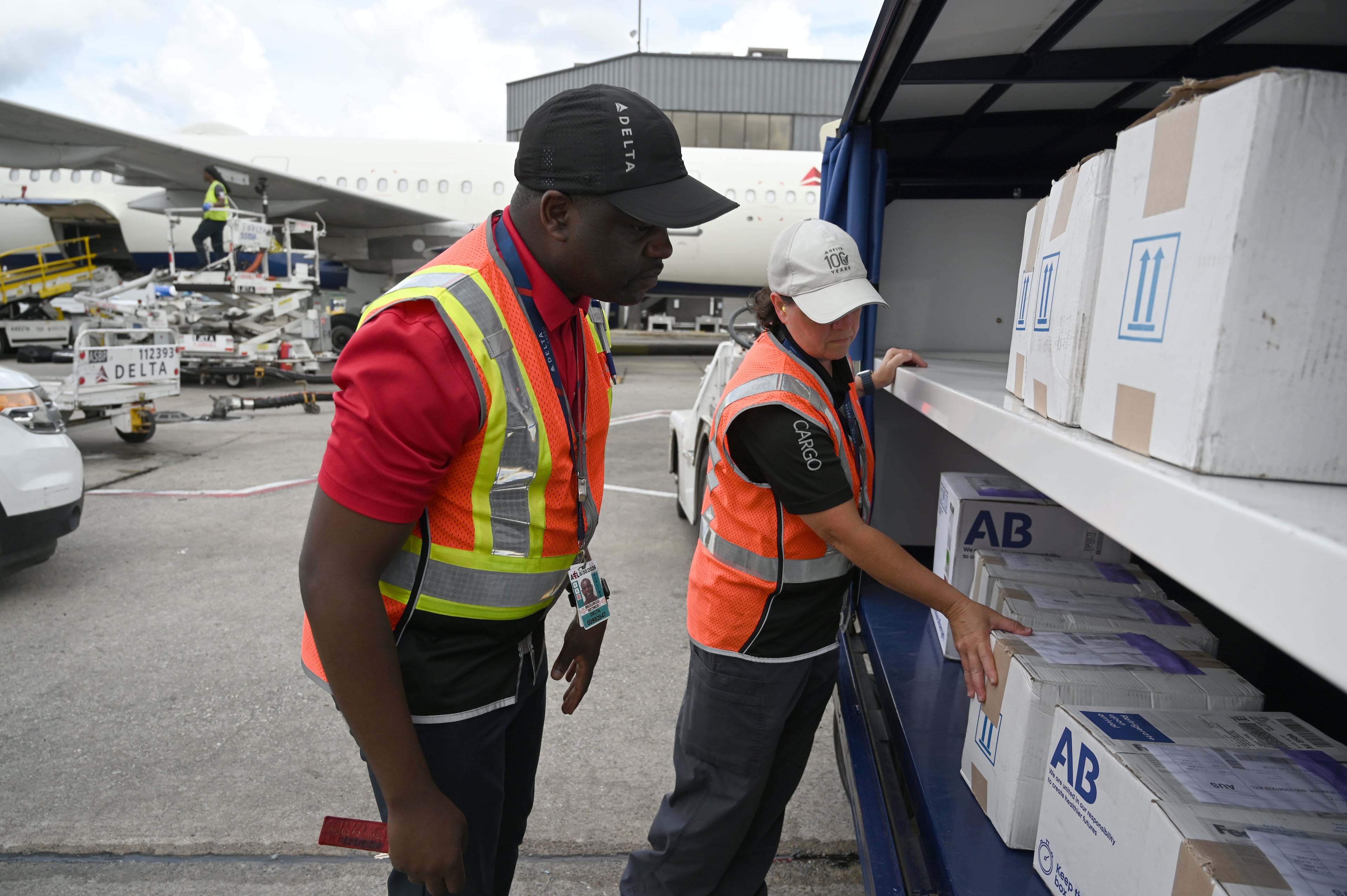 George Musungu (left) general manager of Delta's Atlanta Cargo Operations, and Lori Hamilton, a Delta Air Lines ramp worker, check Delta DASH packages before they are loaded into an aircraft’s cargo hold on the airport ramp at Hartsfield-Jackson Atlanta International Airport. (Hyosub Shin/AJC)