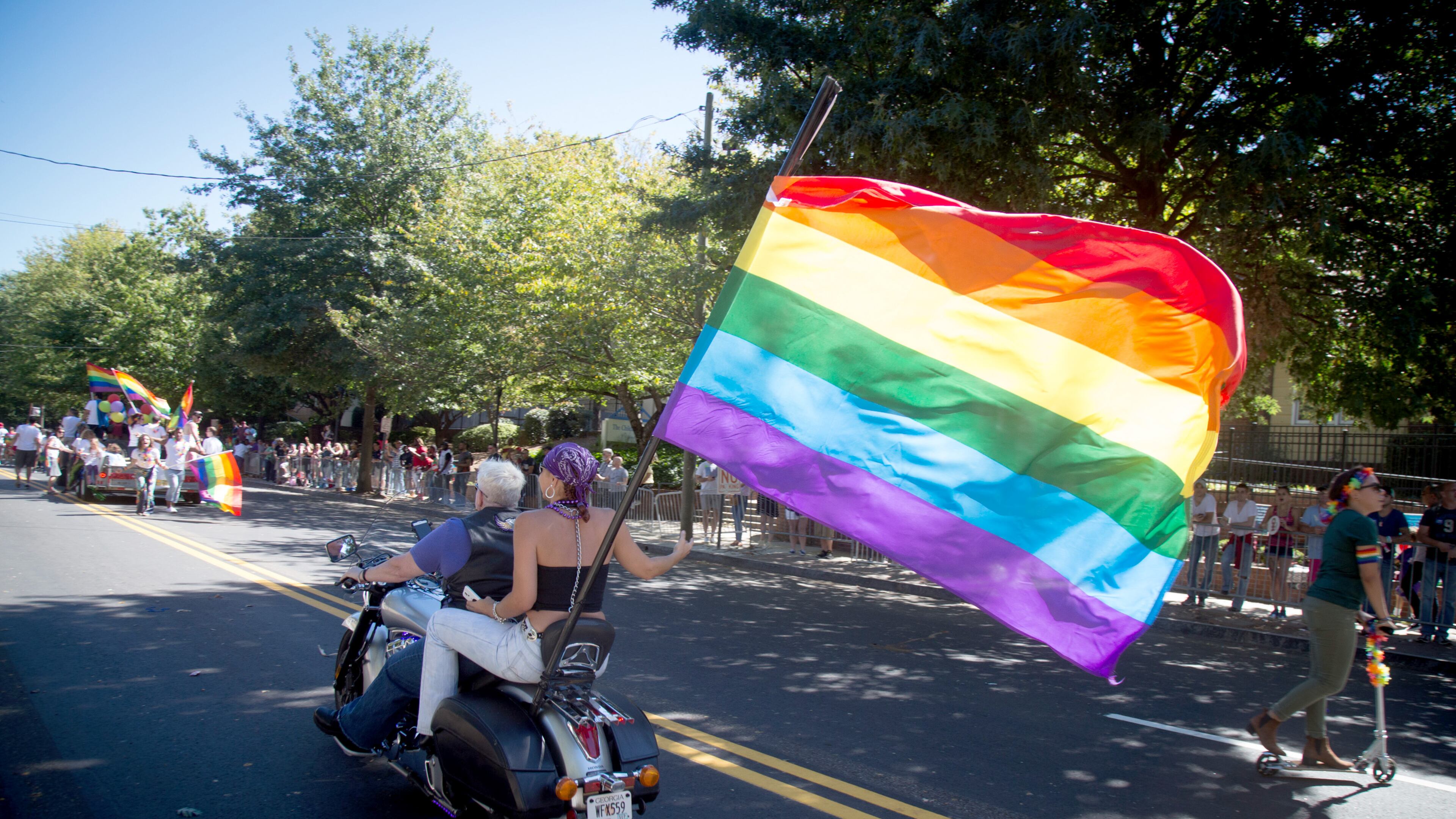 A motorcycle with a large rainbow flag heads up 10th Street during the Atlanta Pride Parade in this October 2016 file photo.