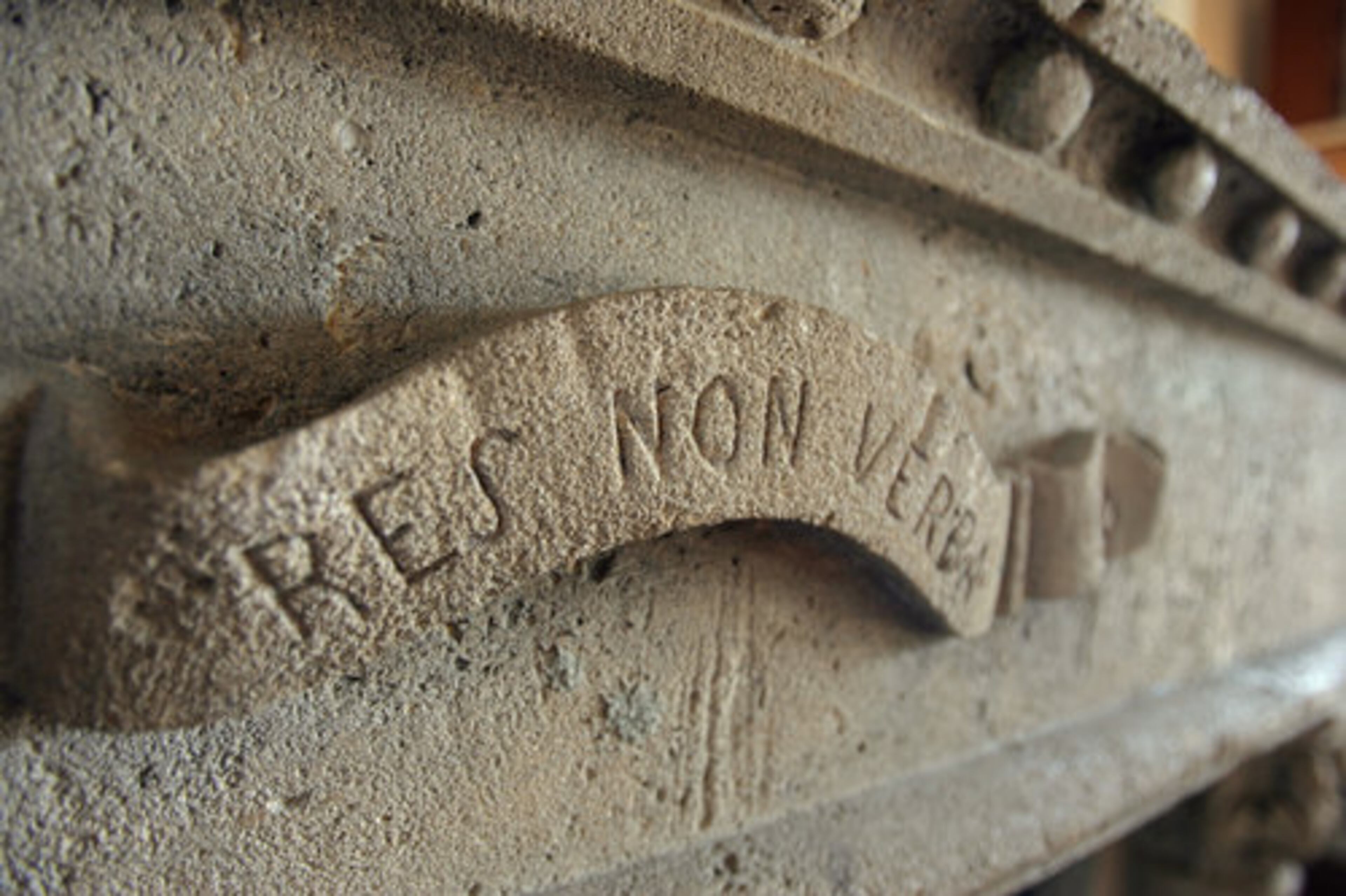 The Latin phrase on the fireplace translates to "Actions not words."