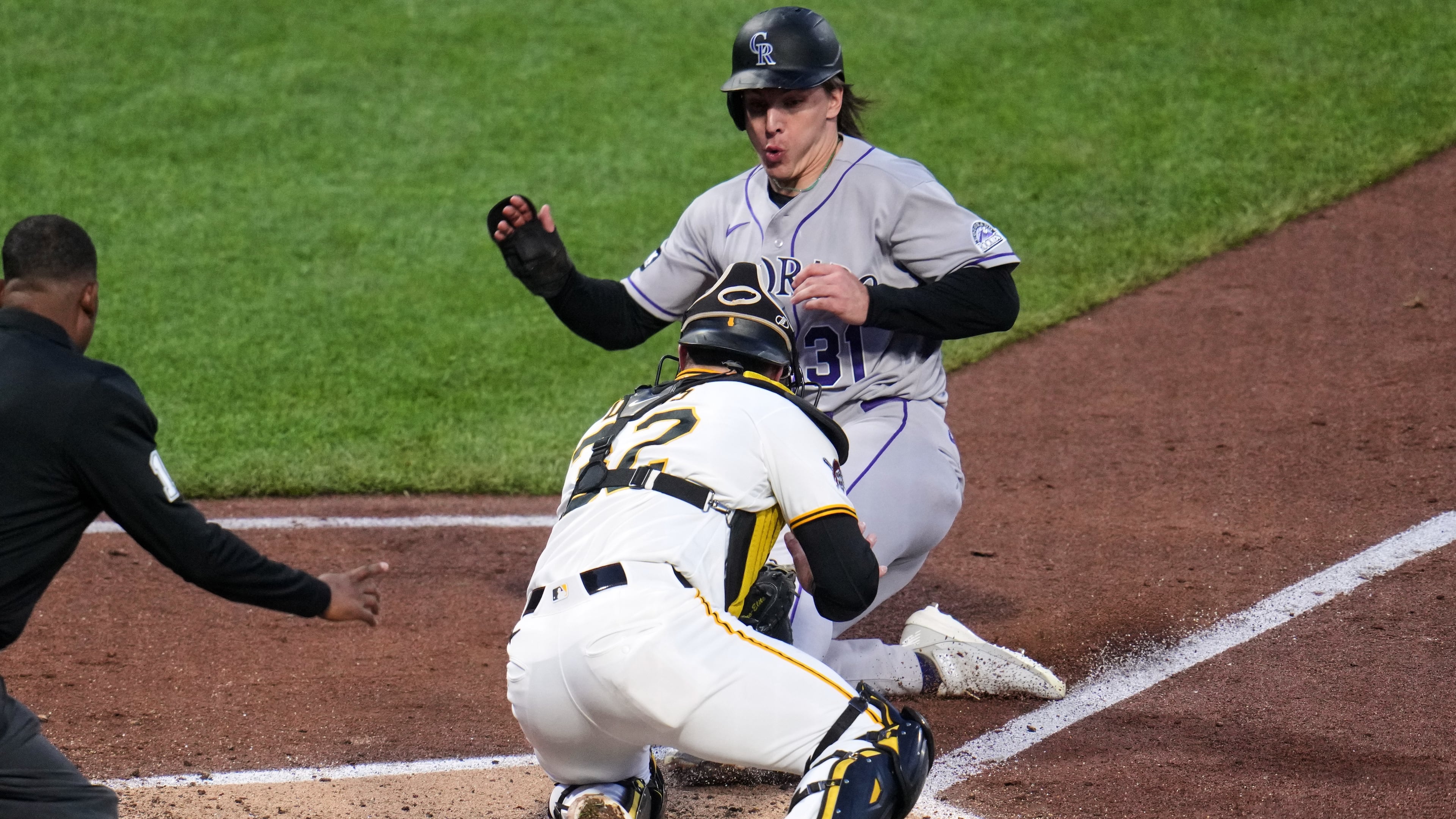 Colorado Rockies' Jake McCarthy, rear, is tagged out by Pittsburgh Pirates catcher Henry Davis attempting to score on a fielder's choice by Brett Sullivan during the fifth inning of a baseball game in Pittsburgh, Wednesday, May 13, 2026. (AP Photo/Gene J. Puskar)