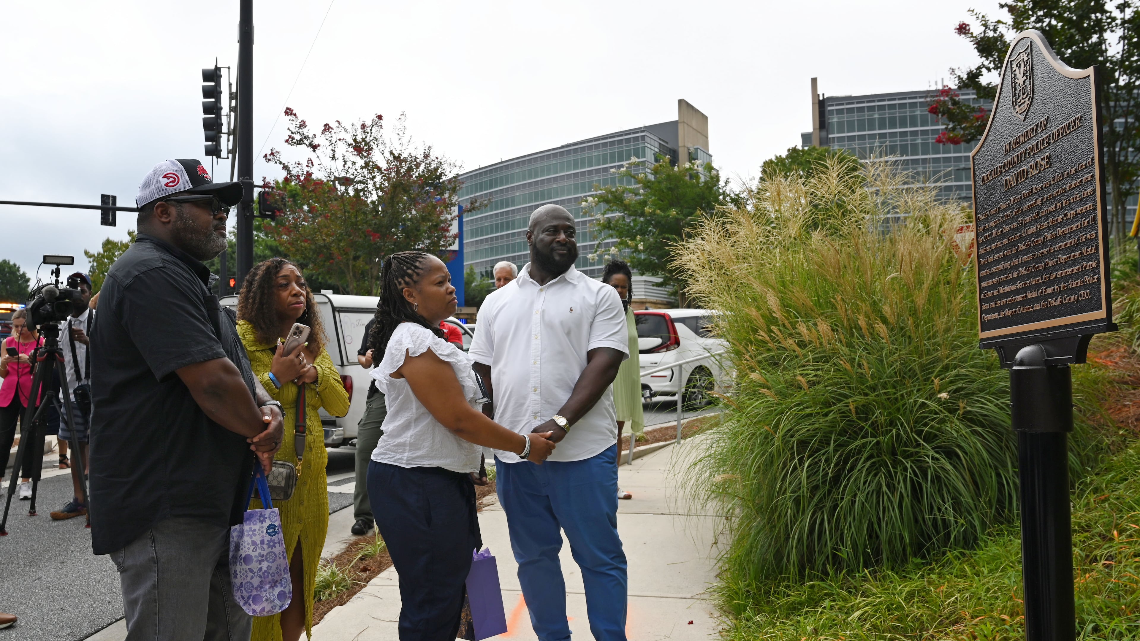 Family members visit a memorial plaque installed in honor of DeKalb County Police Officer David Rose outside the Centers for Disease Control and Prevention in Atlanta on Friday, Aug. 7, 2026. U.S. Secretary of Health and Human Services Secretary Robert F. Kennedy Jr. visited the CDC Friday to mark the one-year anniversary of the shooting that killed Rose. (Hyosub Shin/AJC)