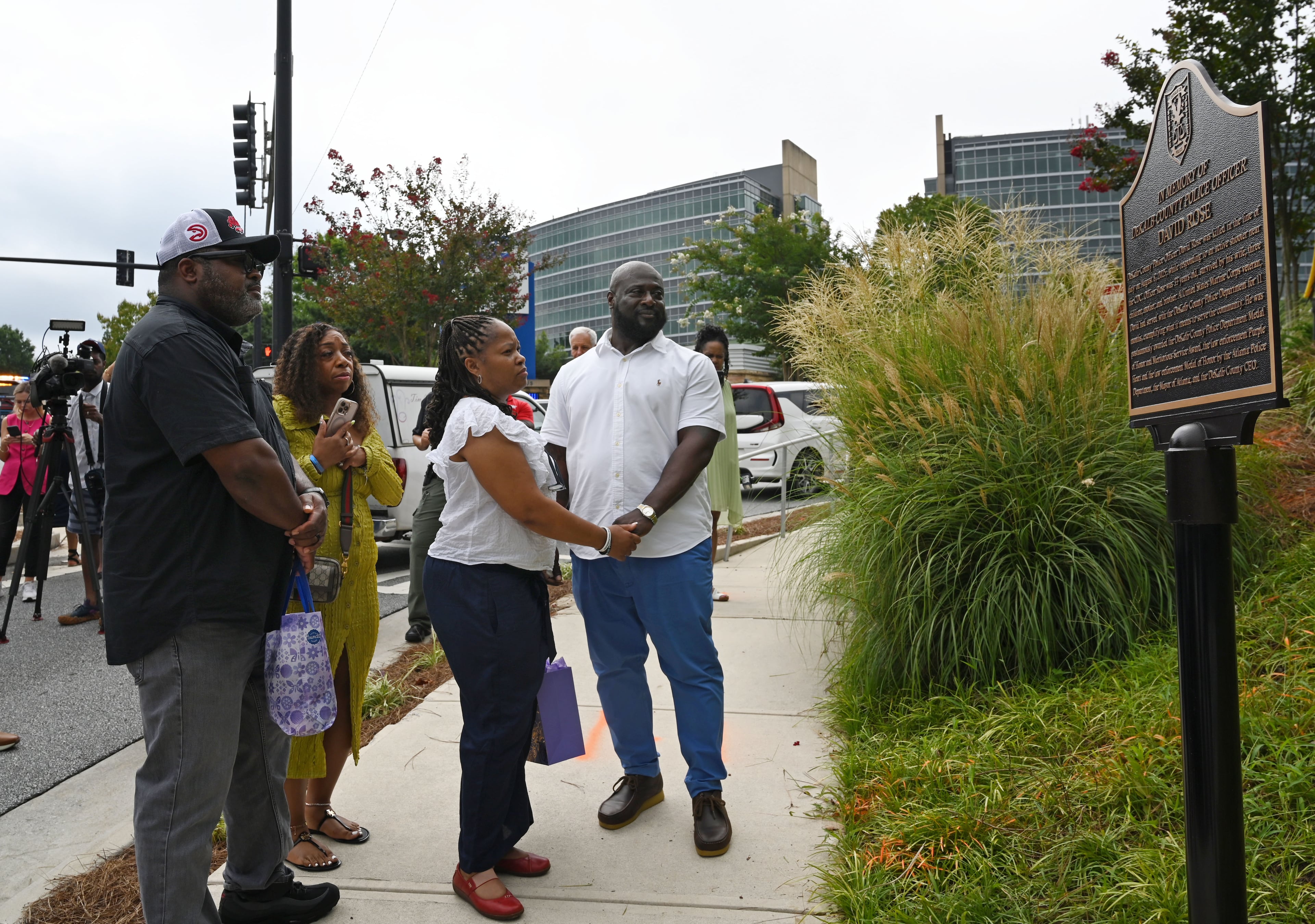 Family members of fallen DeKalb County Police Officer David Rose visit the memorial plaque in honor of fallen officer David Rose outside CDC headquarters on Friday, Aug. 7, 2026, in Atlanta. U.S. Secretary of Health and Human Services Secretary Robert F. Kennedy Jr. visited the Centers for Disease Control and Prevention Friday to mark the one-year anniversary of a shooting that locked down the federal facility for hours and killed a police officer. (Hyosub Shin/AJC)