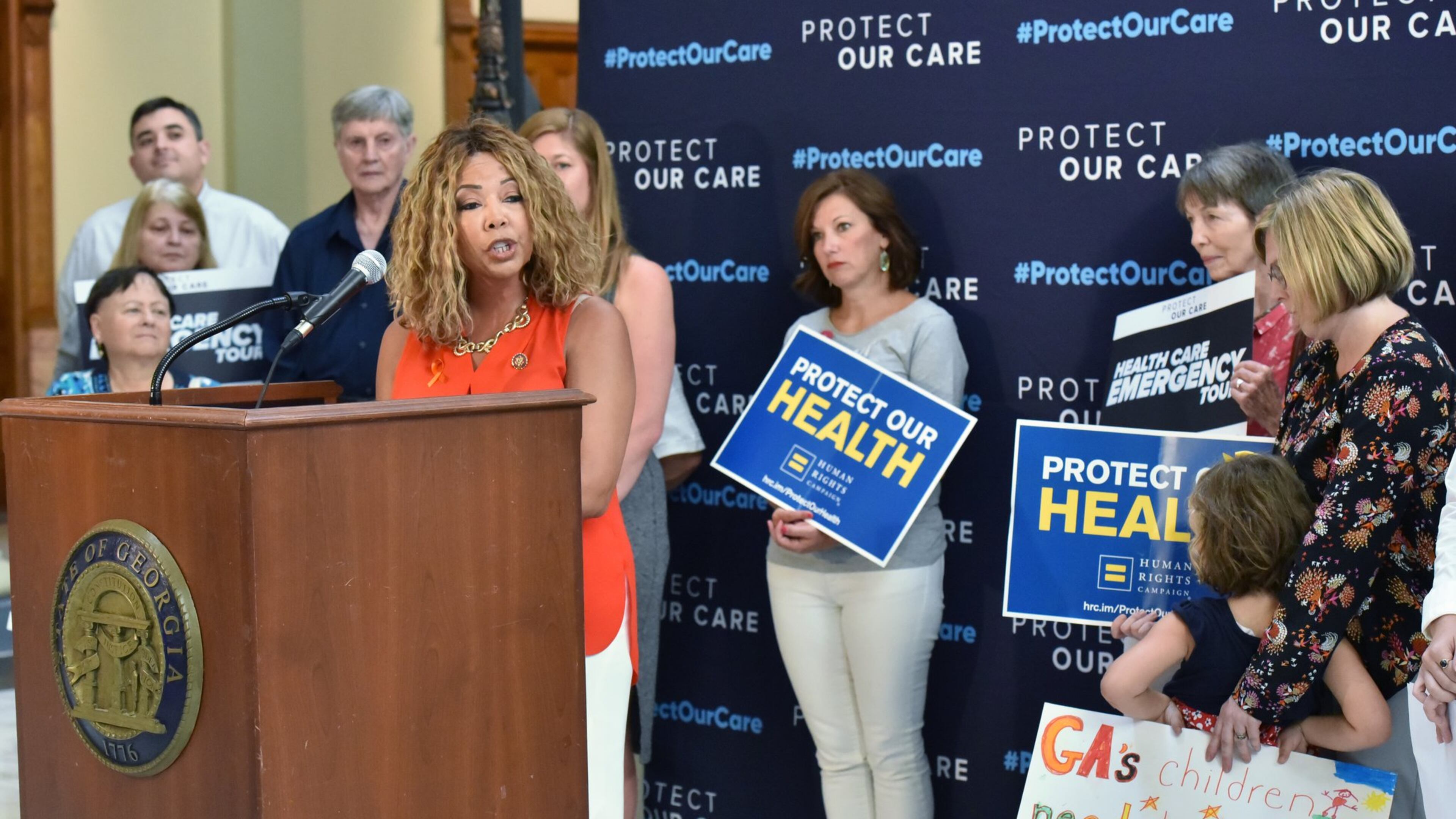 August 23, 2019 Atlanta - U.S. Representative Lucy McBath speaks as Vivienne Sacks (right), 5, holds a sign during “Protect Our Care Georgia Health Care Emergency” Press Conference at the Georgia State Capitol on Friday, August 23, 2019. Protect Our Care “Health Care Emergency” Bus Tour Continues With Stops in Maine, New Hampshire, North Carolina and Georgia. (Hyosub Shin / Hyosub.Shin@ajc.com)