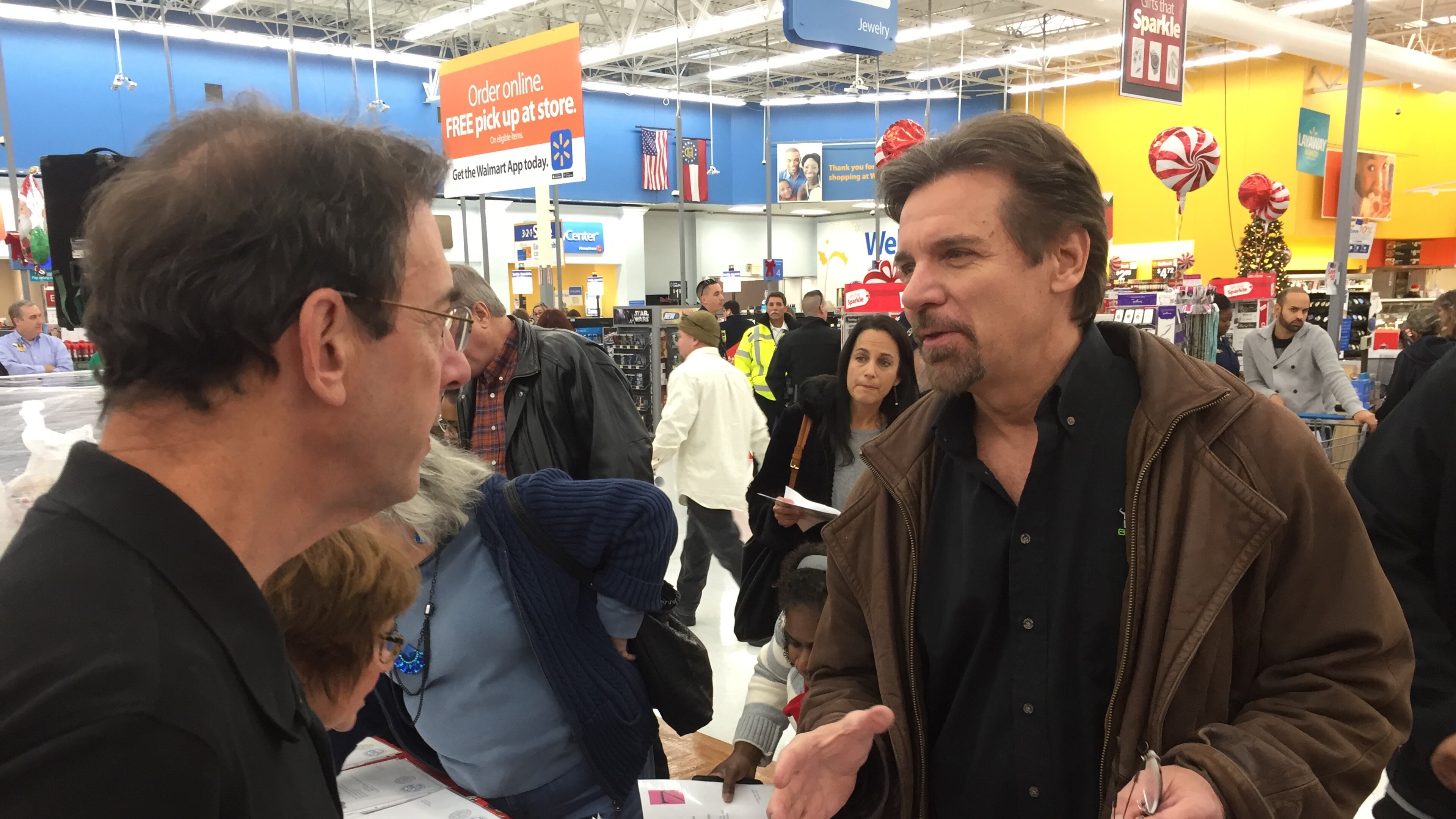 Clark Howard, at the Milton Wal-Mart December 9 for the Clark's Kids toy drive, gabs with BurgerFi franchise owner Ron Altman. CREDIT: Rodney Ho/ rho@ajc.com