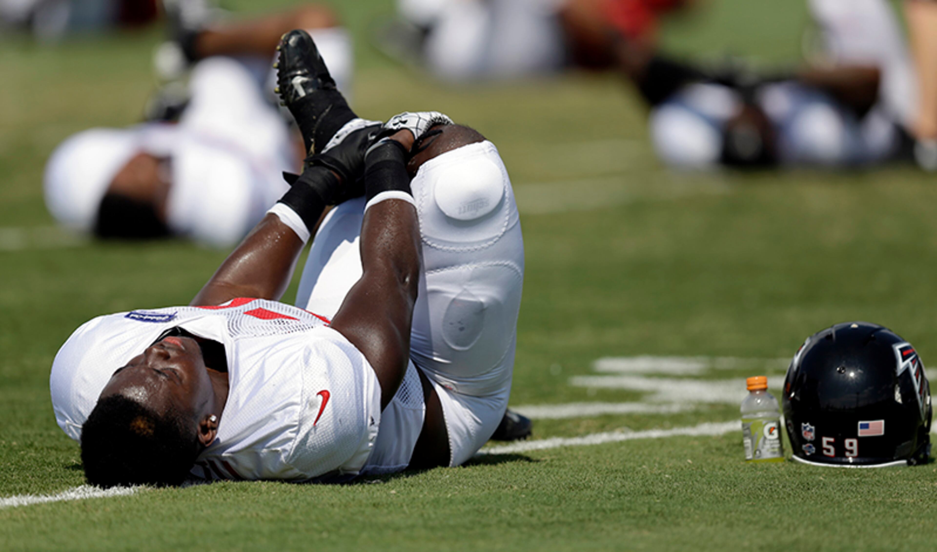 Falcons' Joplo Bartu stretches while wearing knee and thigh pads during training camp. The NFL is making players wear knee and thigh pads this season--even if some of them don't like it. The mandatory leg padding is back for the first time since 1994, when it was dropped because it was too tough to enforce.