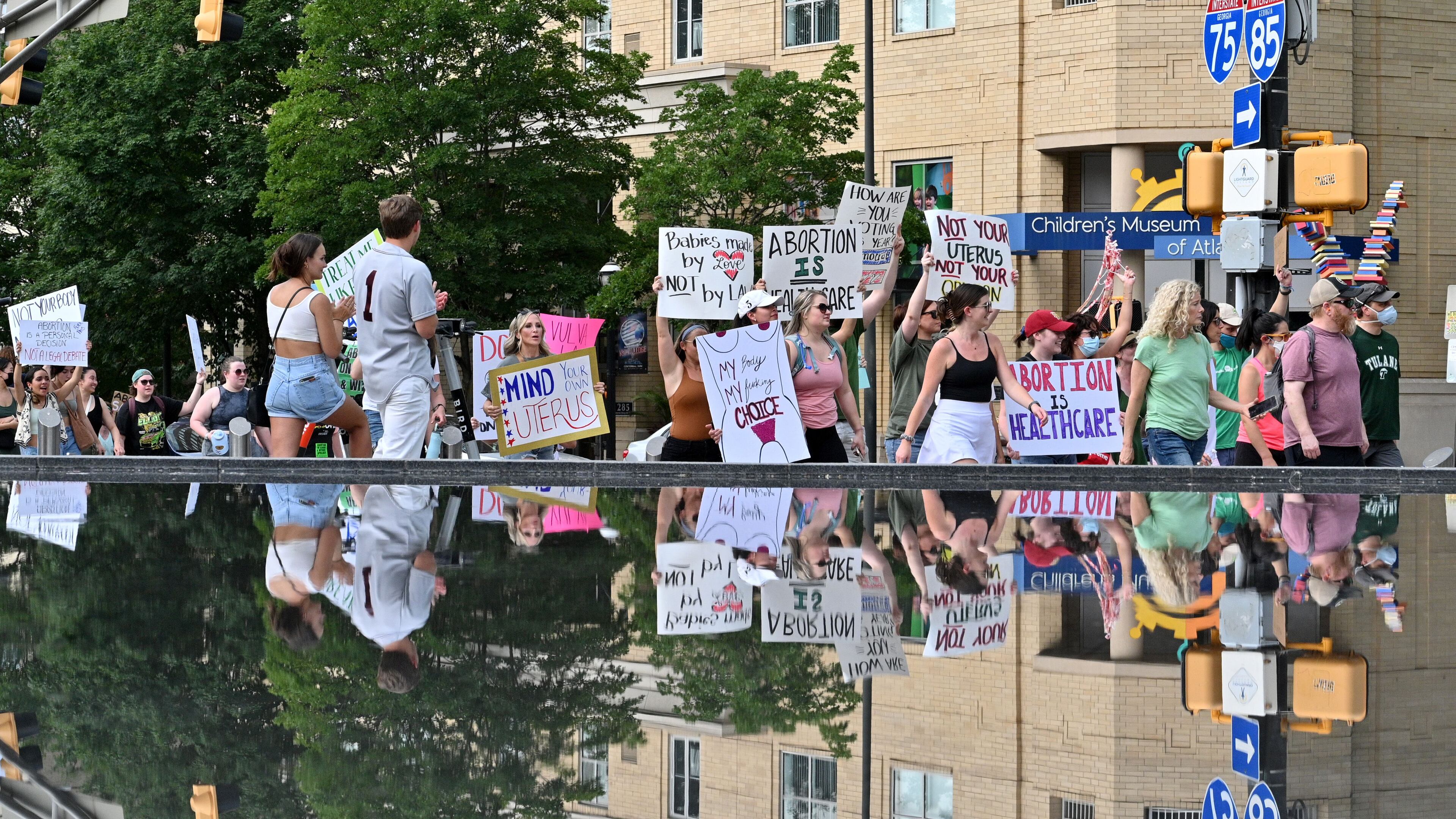 June 25, 2022 Atlanta - People march through Centennial Olympic Park to protest the Supreme Court's decision to overturn Roe v. Wade in downtown Atlanta on Saturday, June 25, 2022. (Hyosub Shin / Hyosub.Shin@ajc.com)