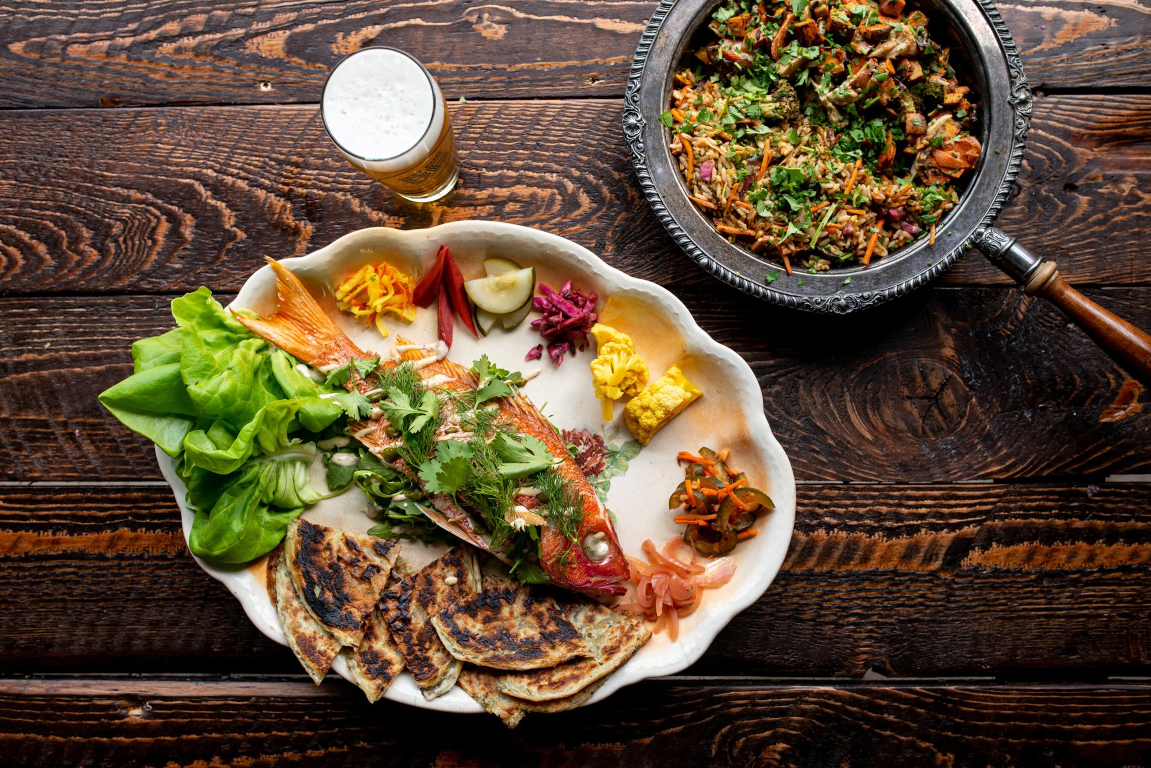 Whole Snapper Family Meal with roti, veggies, and kimchi fried rice. Photo credit- Mia Yakel.