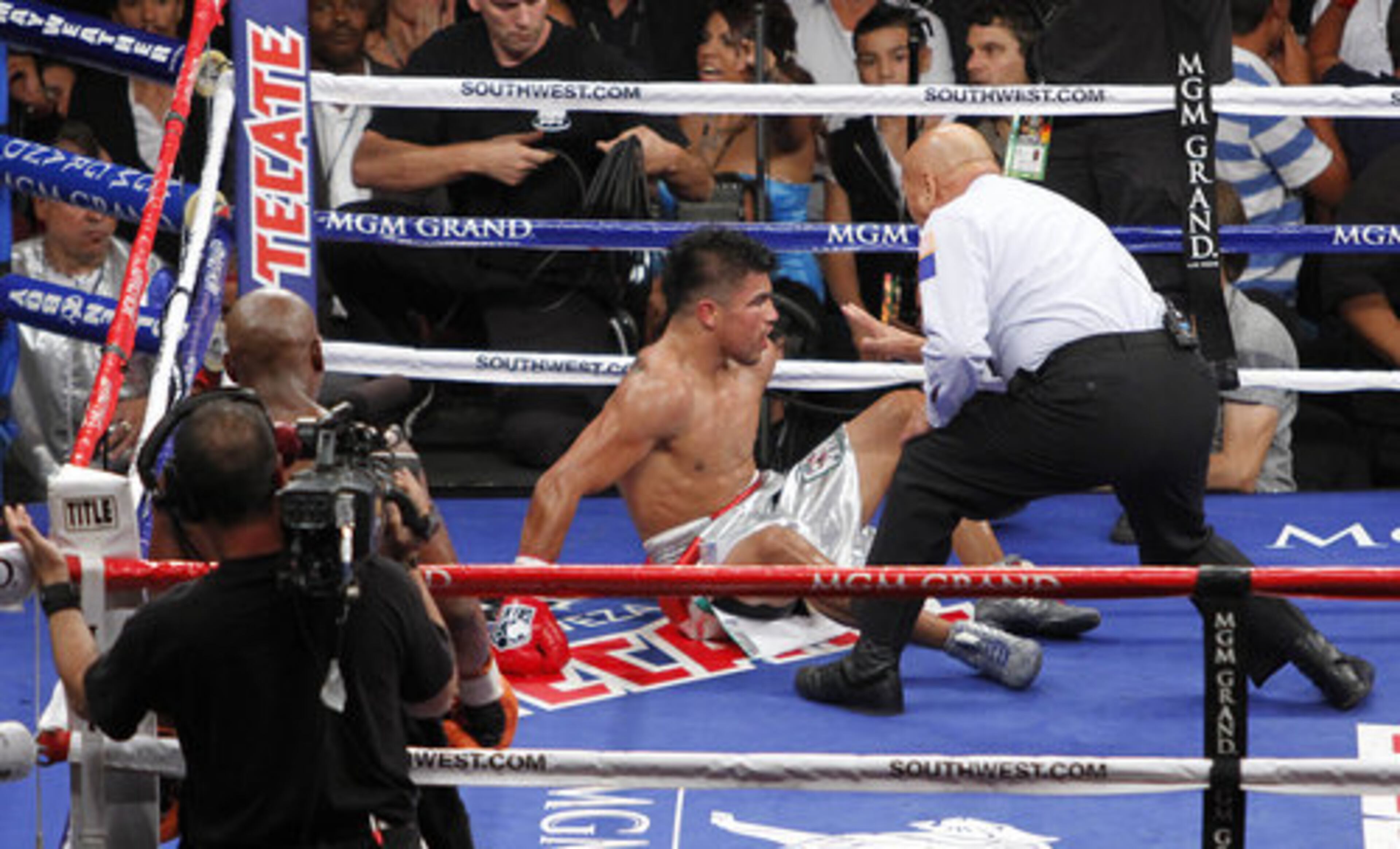 Referee Joe Cortez gives Victor Ortiz, center left, the count after being knocked down by Floyd Mayweather, second from left, in the fourth round during a WBC welterweight title fight.