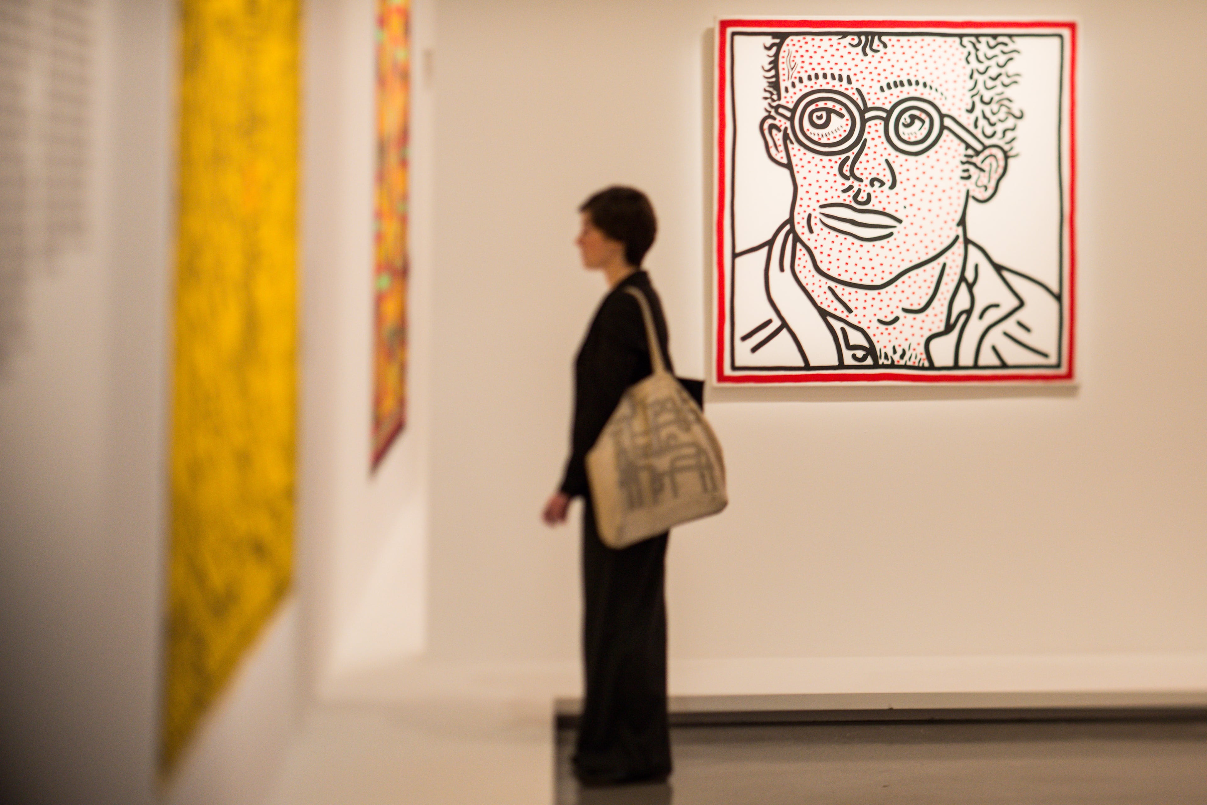 A visitor standing in front of a Keith Harring painting during a press preview at Musee d'Art Moderne on April 18, 2013 in Paris, France. (Photo by Francois Durand/Getty Images)