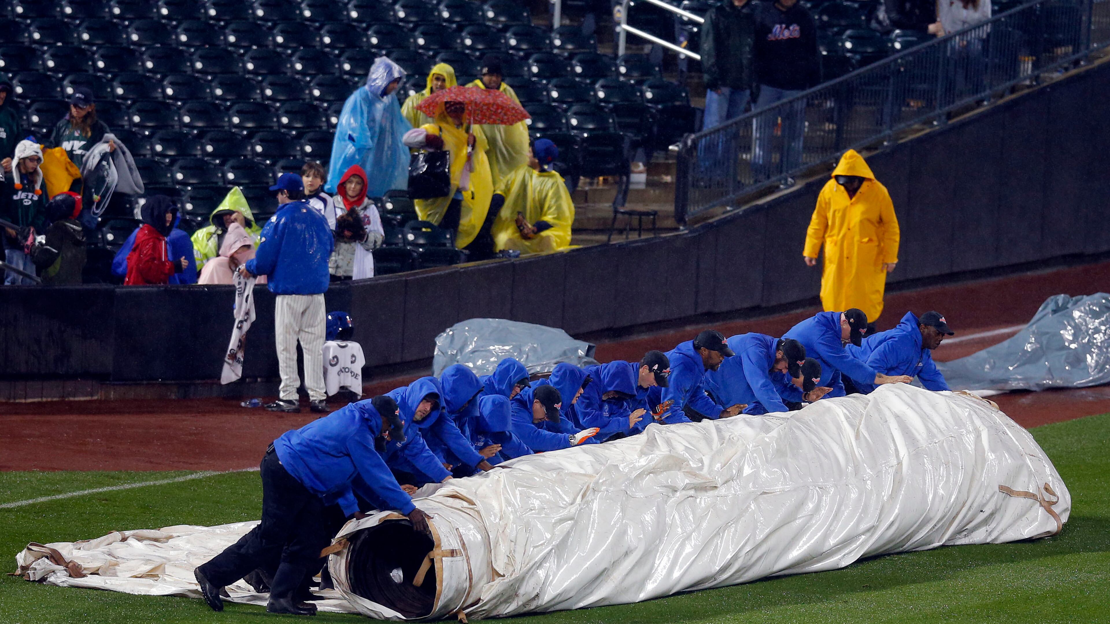 The Citi Field grounds crew rolls out the tarp to cover the field in a heavy rain before the ninth inning with the score tied at 5-5 in a baseball game between the Atlanta Braves and the New York Mets at Citi Field in New York, Friday, May 24, 3013. (AP Photo/Paul J. Bereswill)