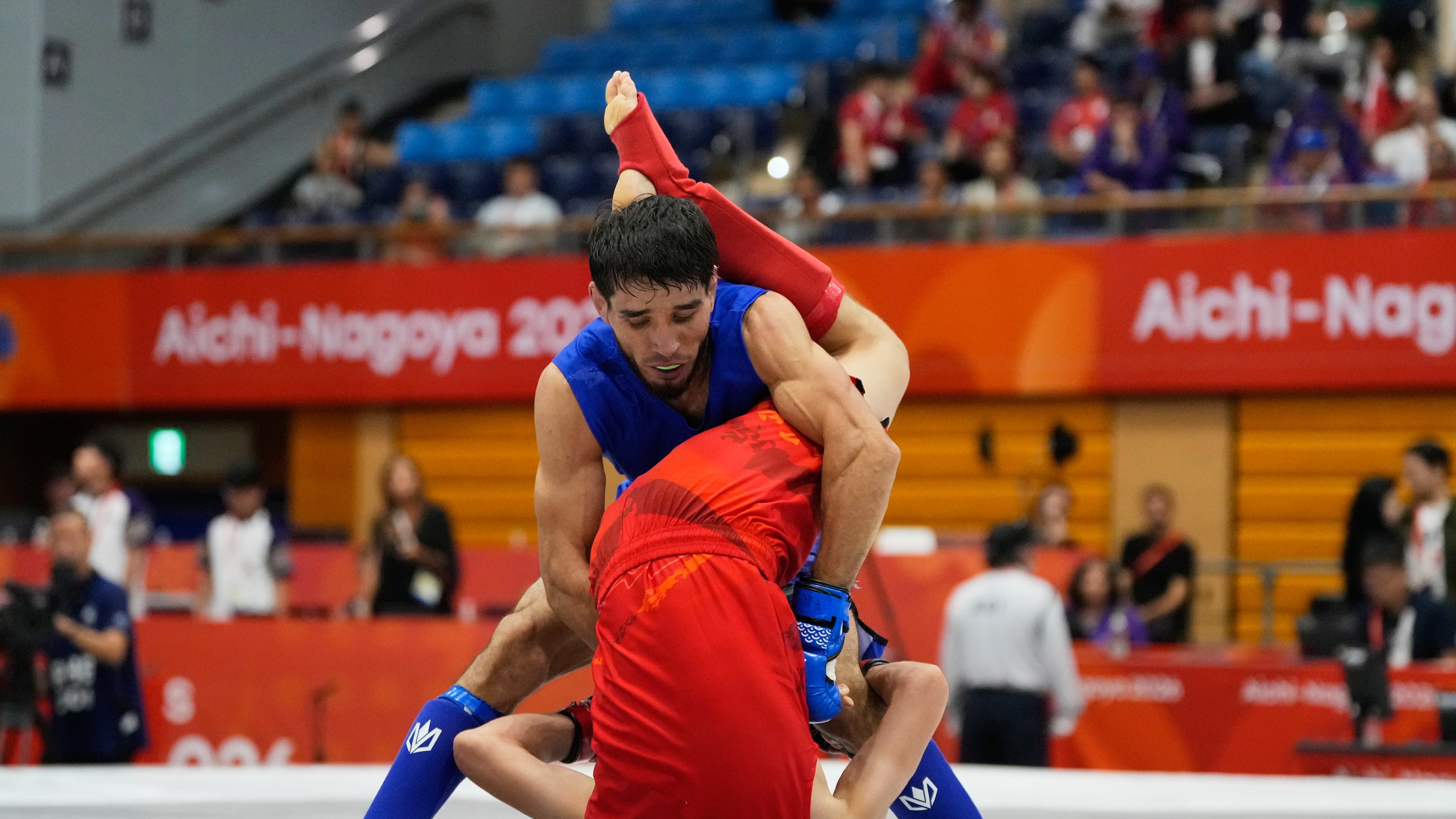 Firdaus Atamuratov of Uzbekistan, bottom, competes with Mirzobek Umarov of Tajikistan during their men's modern 60kg mixed martial arts final at the Asian Games in Nagoya, Japan, Tuesday, Sept. 22, 2026. (AP Photo/Dita Alangkara)