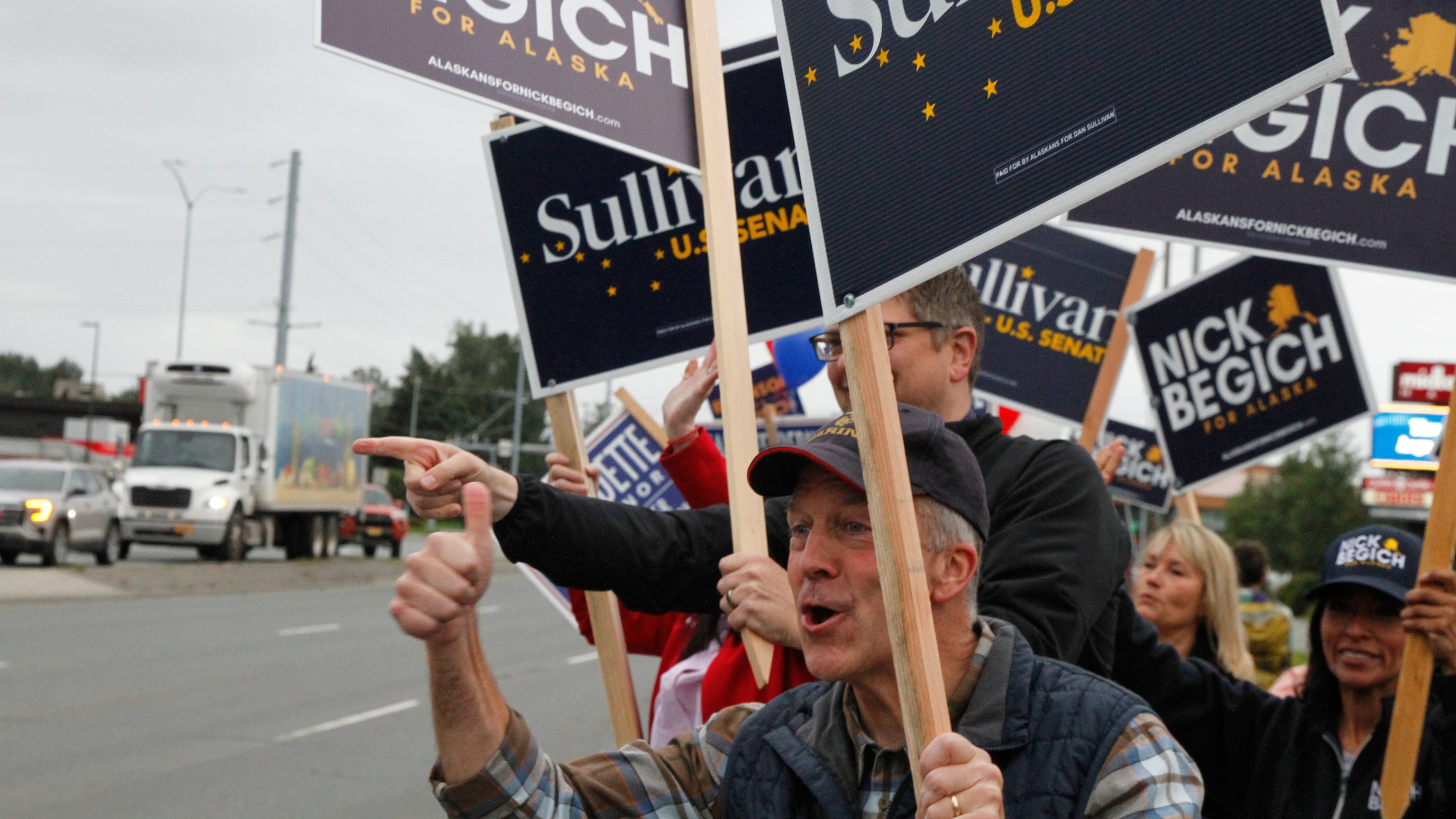 Sen. Dan Sullivan, R-Alaska, who is seeking a third term, flashes a thumbs up after a passing motorist honked during a sign waving event at an intersection on primary election day in Anchorage, Alaska, Tuesday, Aug. 18, 2026. (AP Photo/Mark Thiessen)