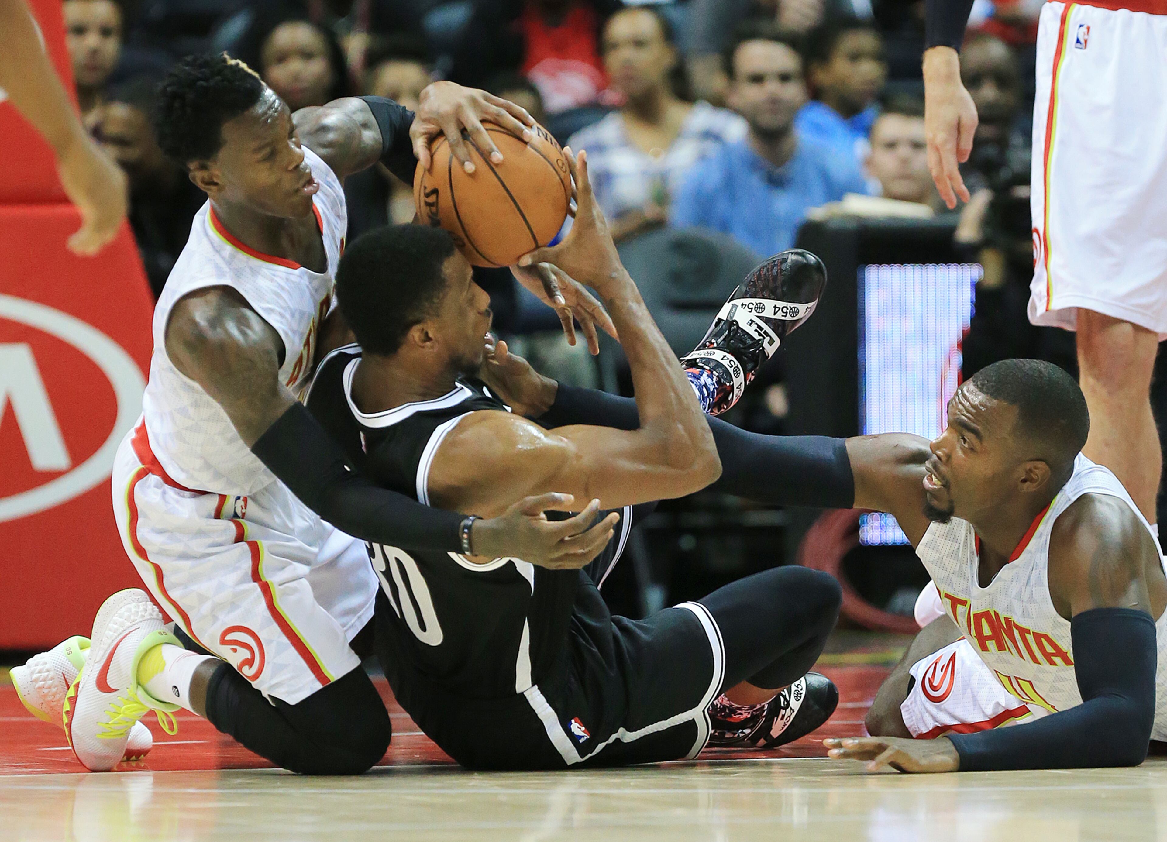 110415 ATLANTA: -- Hawks defenders Dennis Schroder (left) and Paul Millsap battle Nets Thaddeus Young for the ball during the first period in a basketball game on Wednesday, Nov. 4, 2015 in Atlanta. Curtis Compton / ccompton@ajc.com