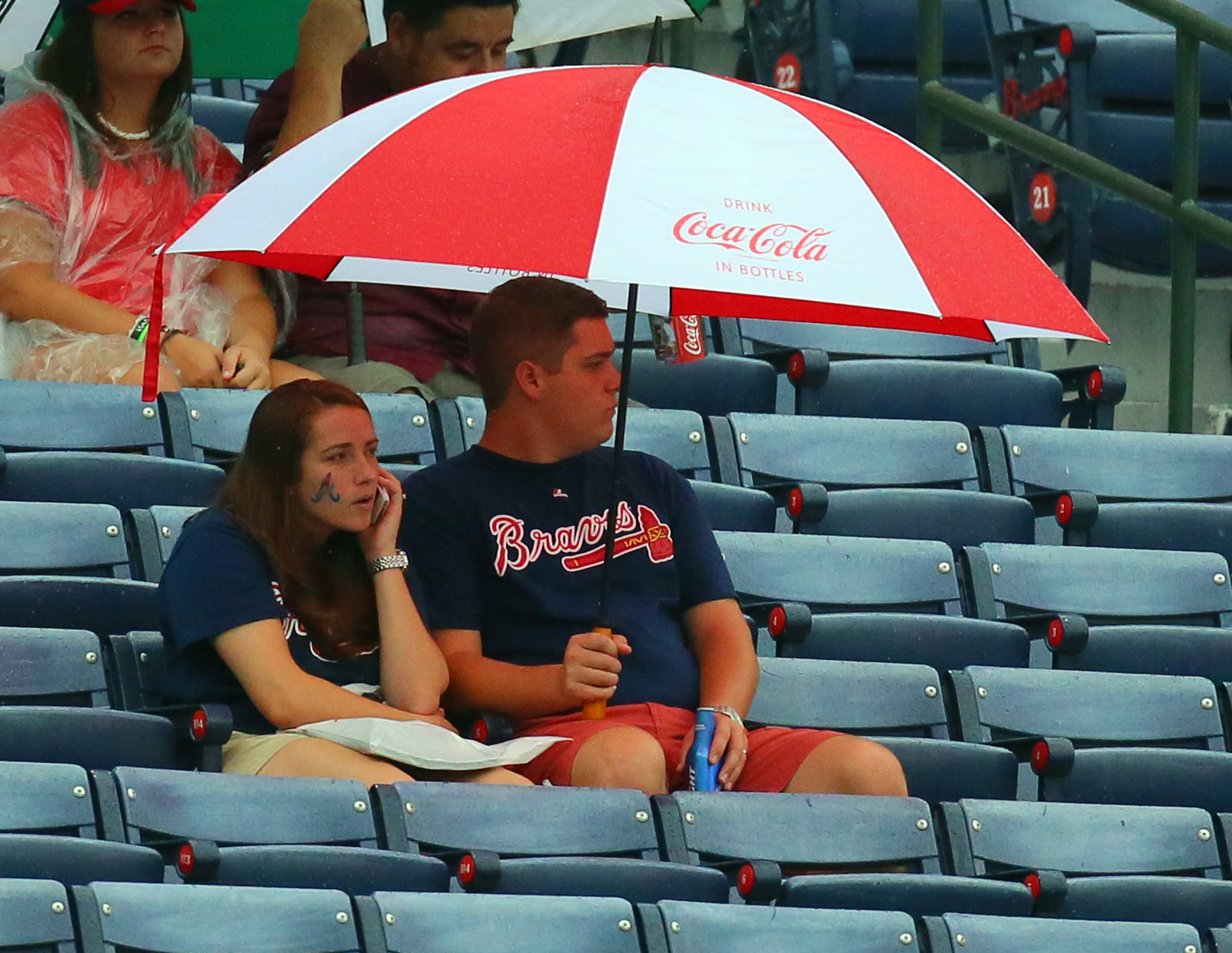 Braves fans wait for the rain to clear out before the Braves play the Marlins on Sunday, Sept. 1, 2013, in Atlanta.