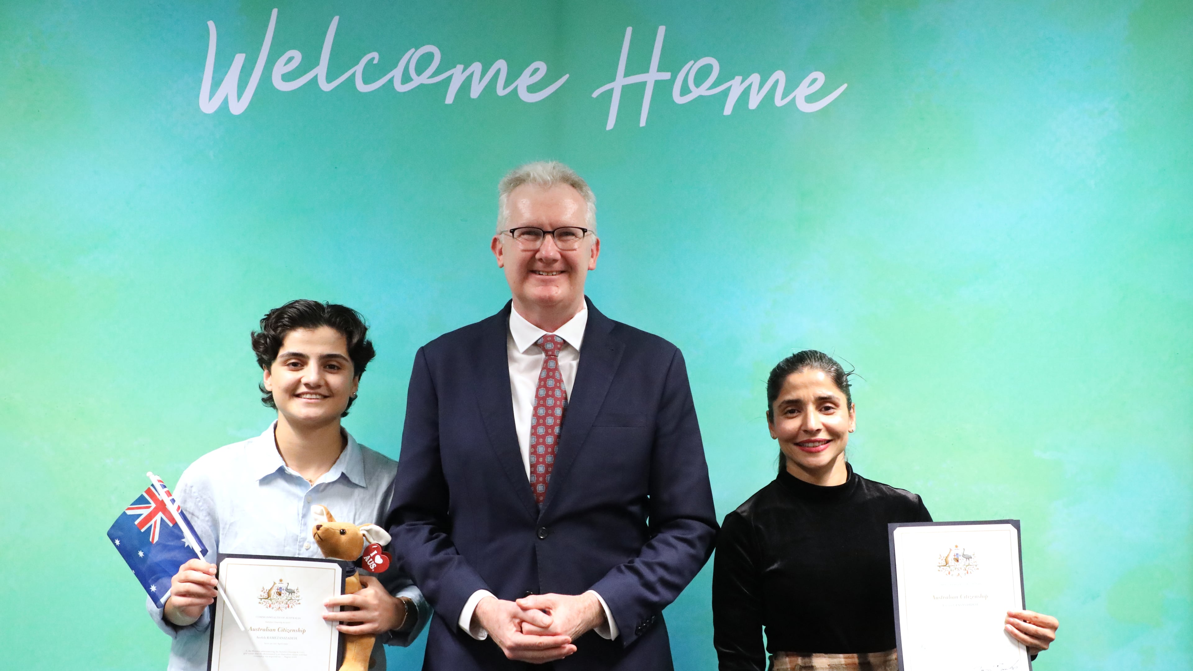 Fatemeh Pasandideh, left, and Atefeh Ramezanisadeh, former members of the Iranian women’s soccer team, stand with Australia's Minister for Home Affairs, Tony Burke, after receiving their citizenship in Brisbane, Australia, Wednesday, Aug. 5, 2026. (Department of Home Affairs via AP)