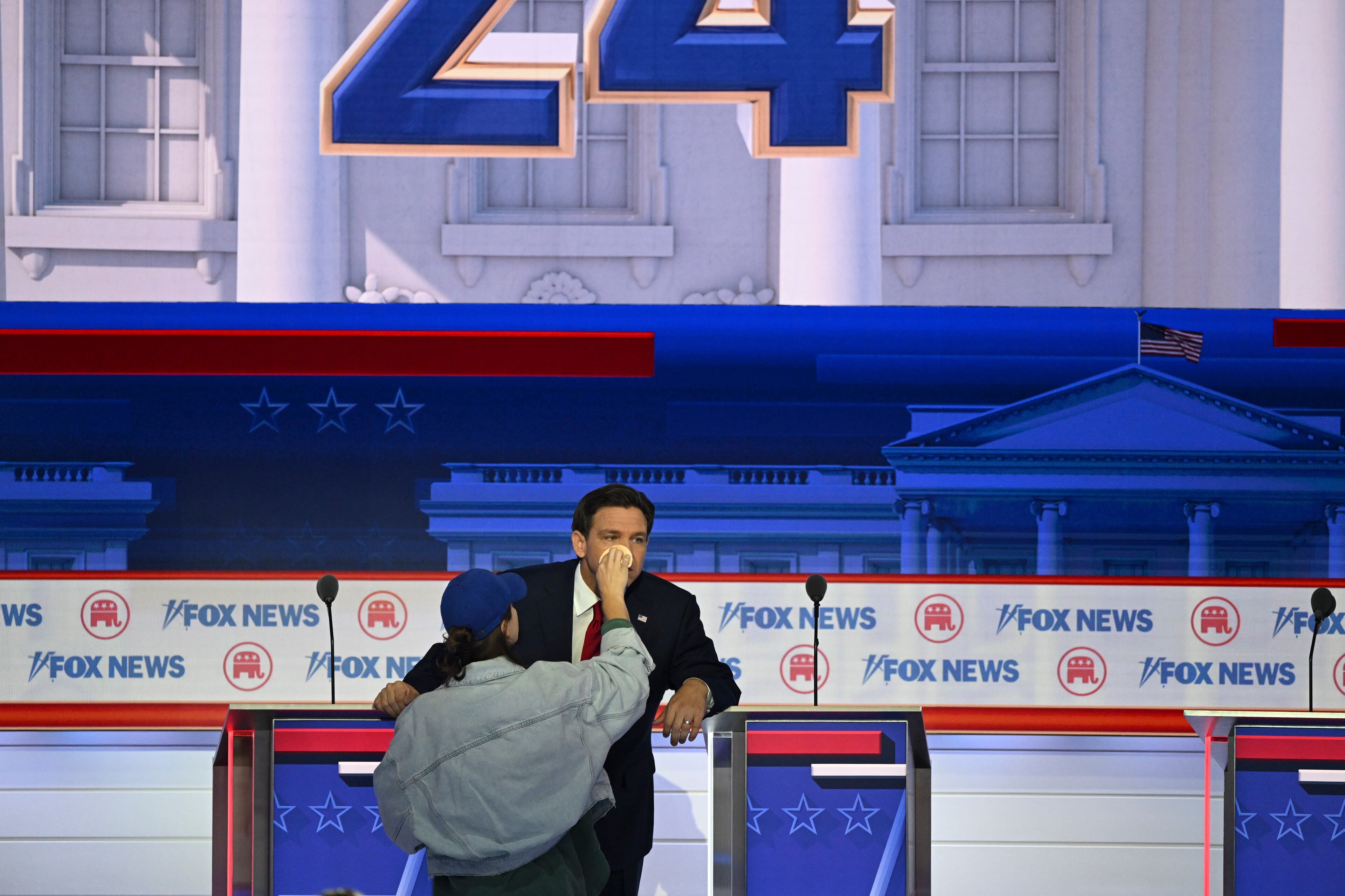 A makeup artist assists Gov. Ron DeSantis of Florida on stage during the first Republican presidential primary debate, at the Fiserv Forum in Milwaukee on Wednesday, Aug. 23, 2023. (Kenny Holston/The New York Times)