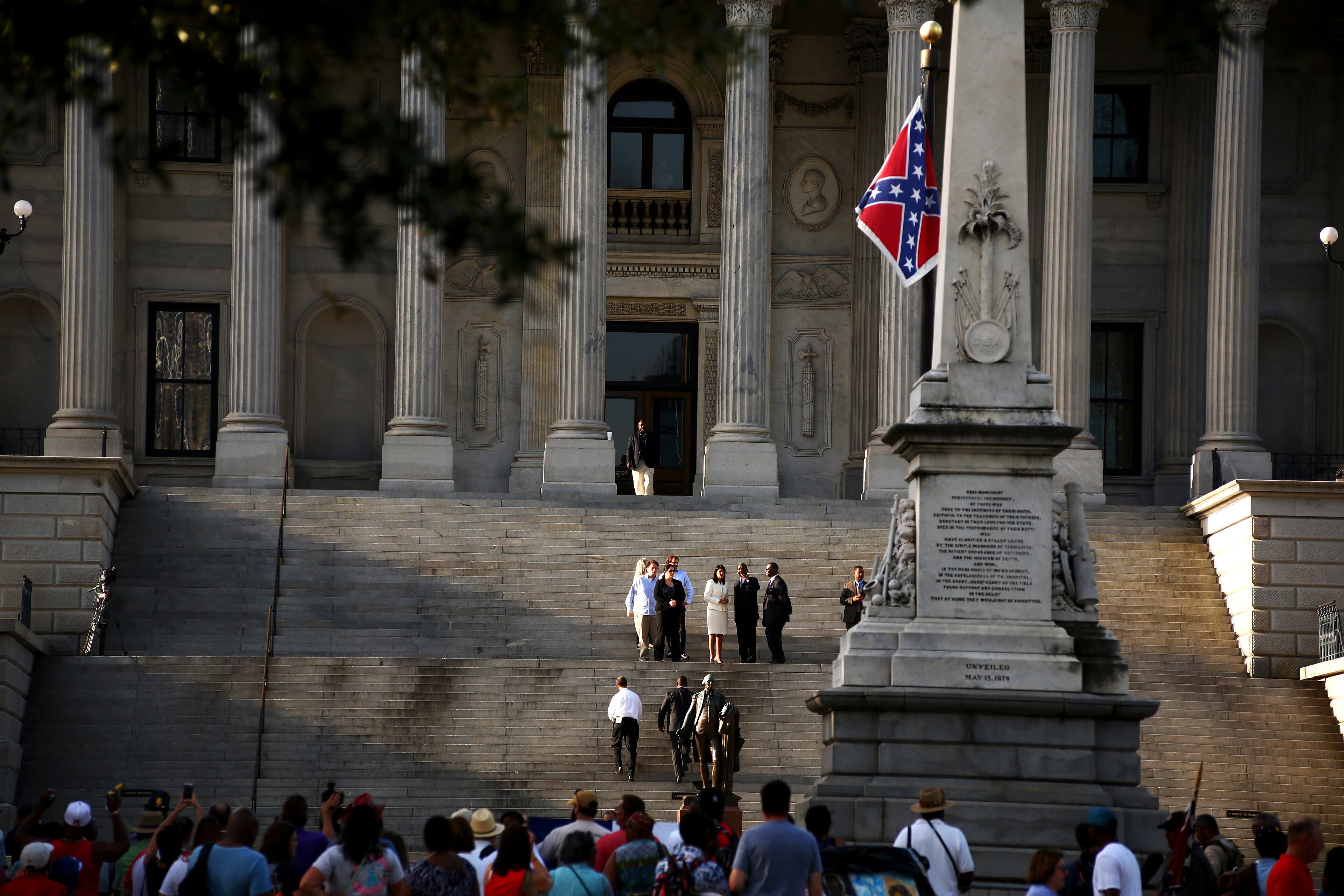 Gov. Nikki Haley , center, in white, stands on the steps of the State House before participating in the removal of the Confederate battle flag the government complex's grounds, in Columbia, S.C., July 10, 2015. In a historic moment for South Carolina, the flag is set to be removed from a 30-foot pole on Friday morning. (Stephen B. Morton/The New York Times)