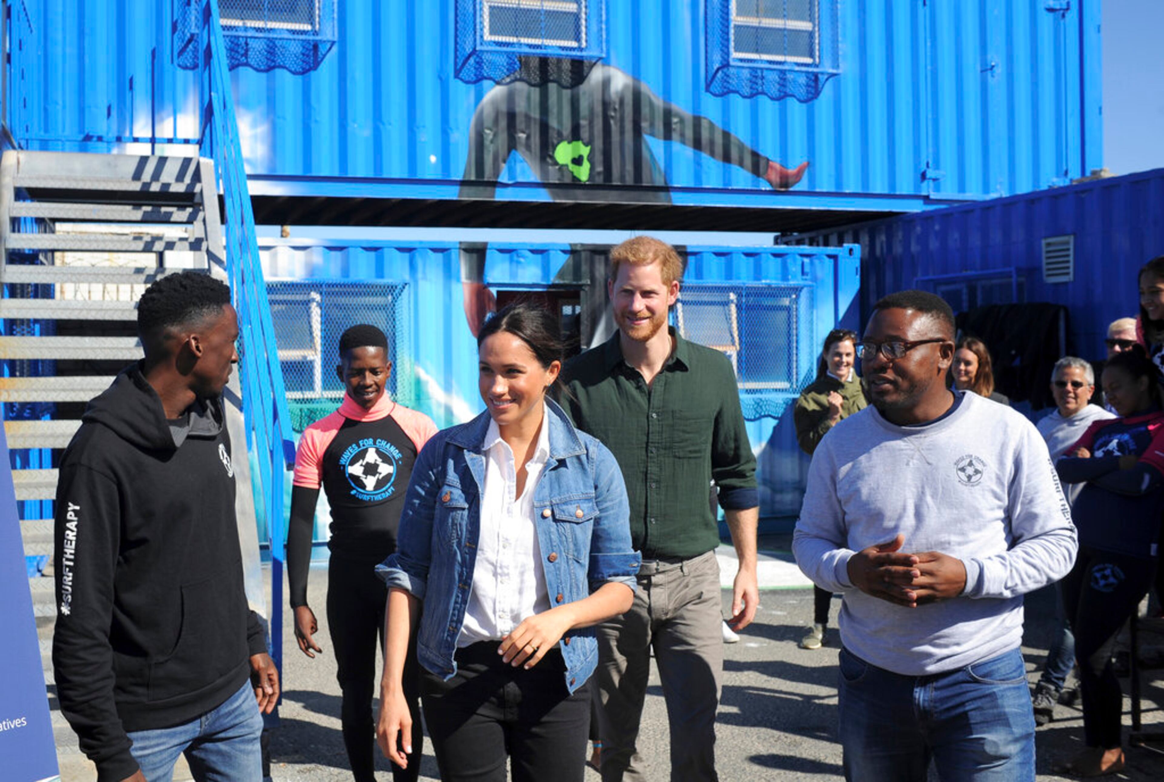 Britain's Prince Harry and Meghan, Duchess of Sussex are shown around the Waves of Change NGO project at Monwabisi Beach, Cape Town, South Africa, Tuesday Sept, 24, 2019. Prince Harry and his wife Meghan began their first official tour as a family with their infant son, Archie, in South Africa on Monday. Their 10-day, multi-country tour is focusing on women's empowerment, wildlife protection, entrepreneurship, mental health and mine clearance. (Henk Kruger/Pool via AP)
