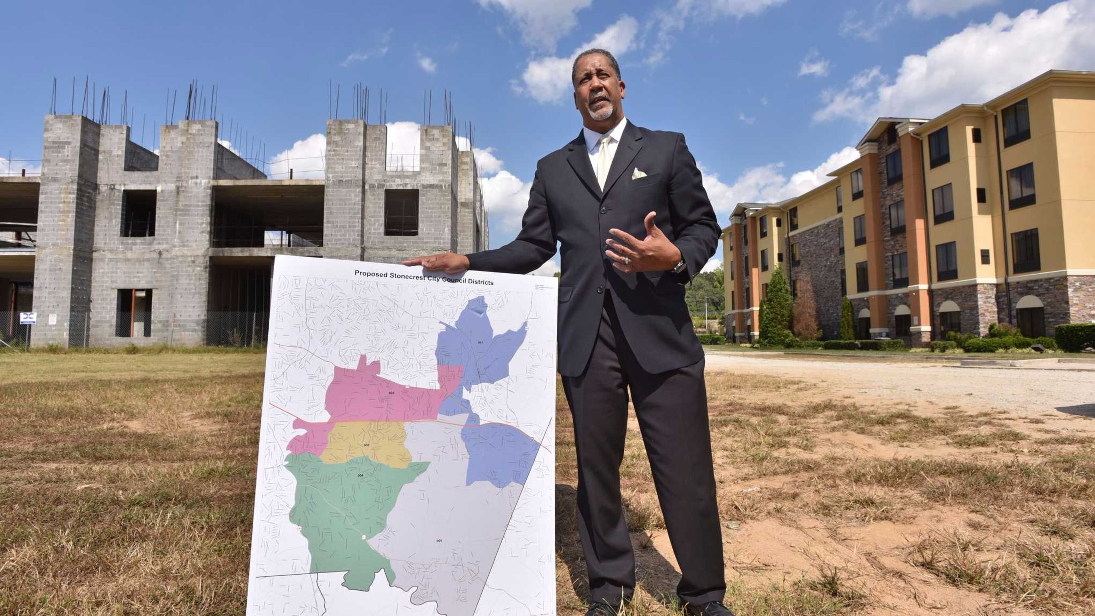 Jason Lary, the president for Stonecrest Yes, holds a map of the proposed city of Stonecrest as he talks about why he believes the area should incorporate in front of an unfinished hotel near Stonecrest Mall. Voters will decide whether to create the city of Stonecrest in a Nov. 8 referendum. HYOSUB SHIN / HSHIN@AJC.COM