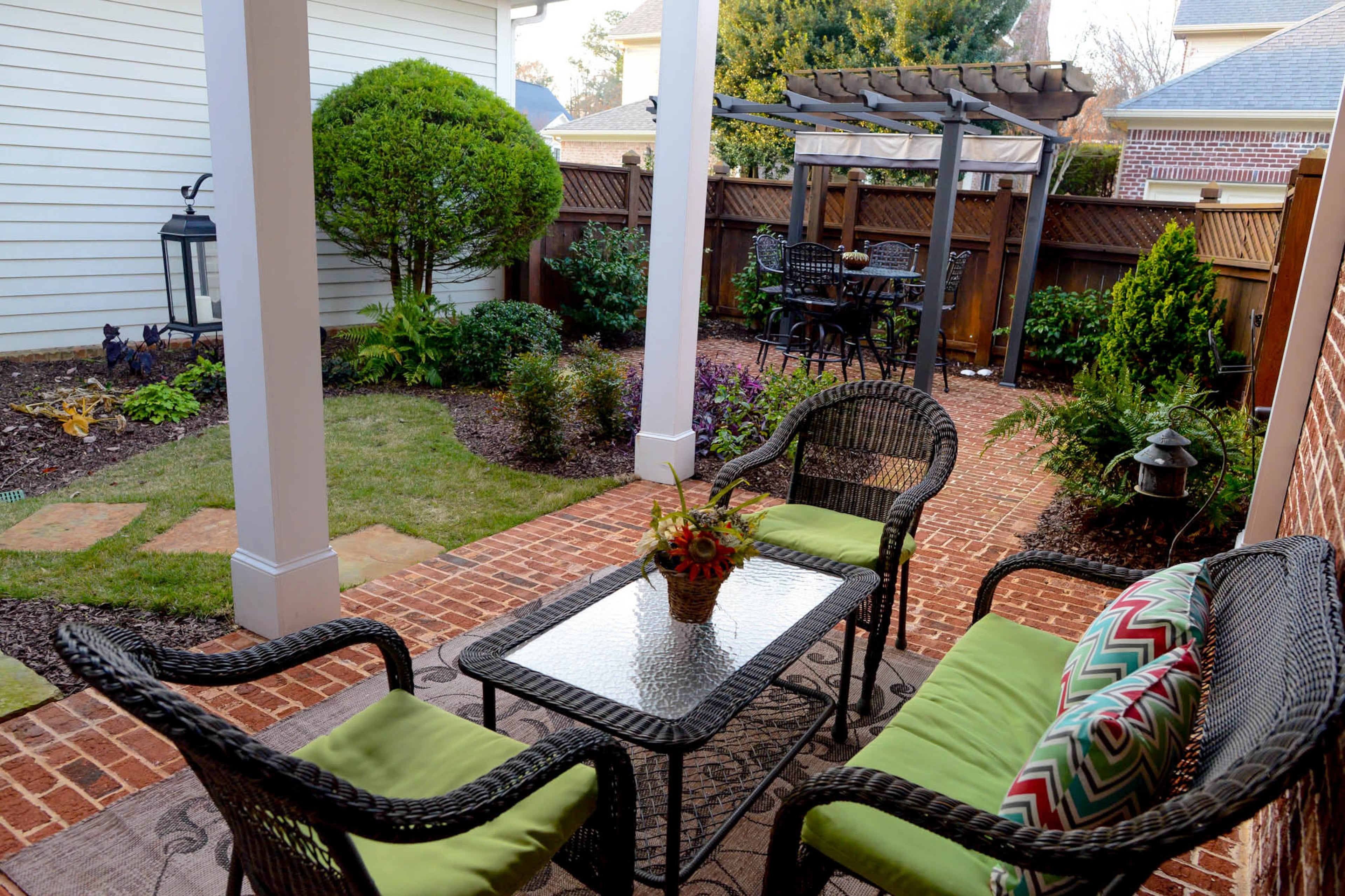 The courtyard is spacious enough for two seating areas. The Callahans added the pergola with a high-top bar table patio set that they enjoy using as a dining space. The backyard was a part of the $41,000 renovations. Scott Tolbert provided the landscape design.