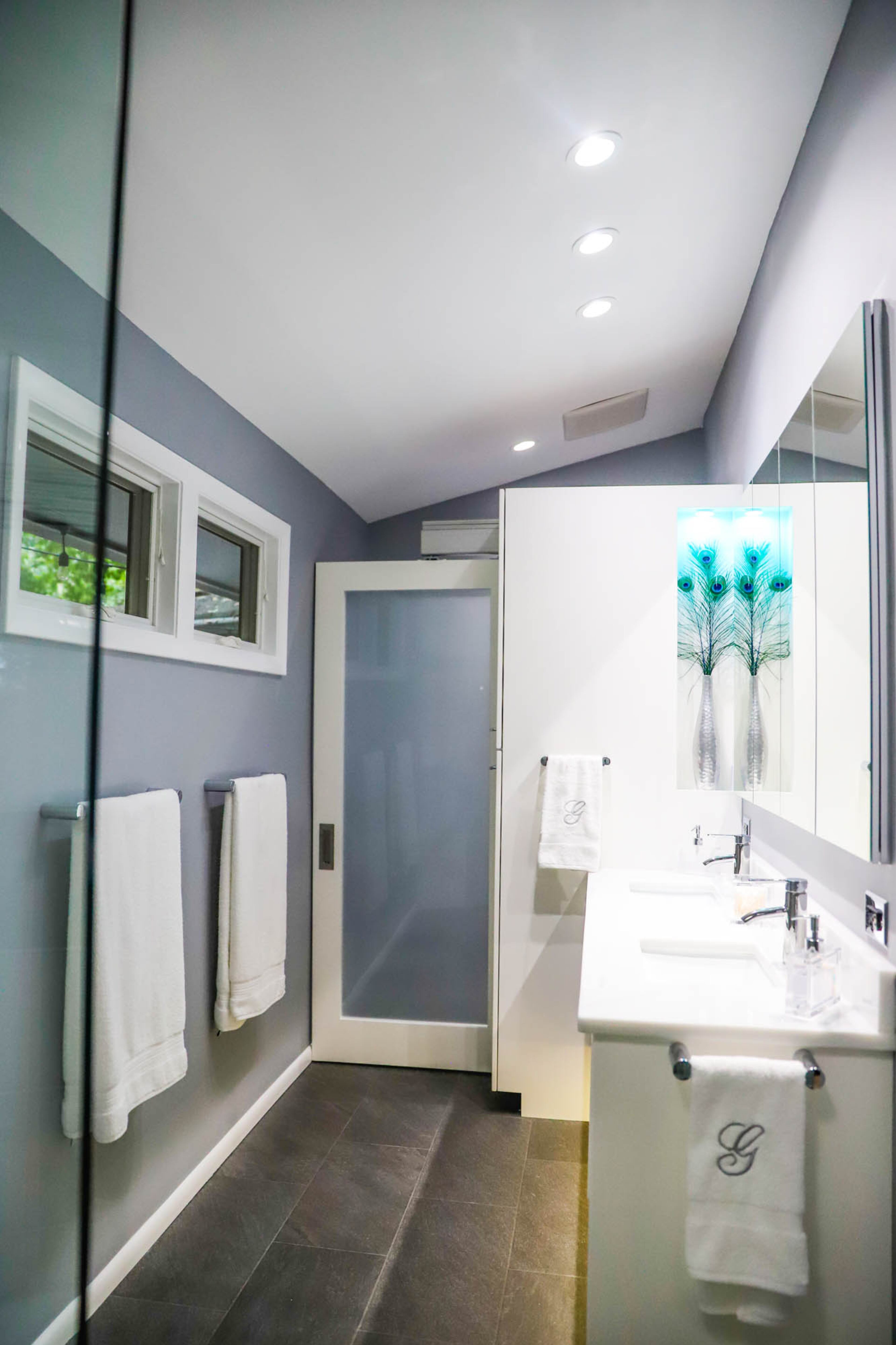 The Galeys expanded the bathroom by 4 inches and added elements like heated Schluter floors from Traditions in Tile and Stone, a raised Infinity by Marvin window for light and privacy, a Crowderslide accordion door to the water closet and even a USB charger beneath the toilet paper holder.