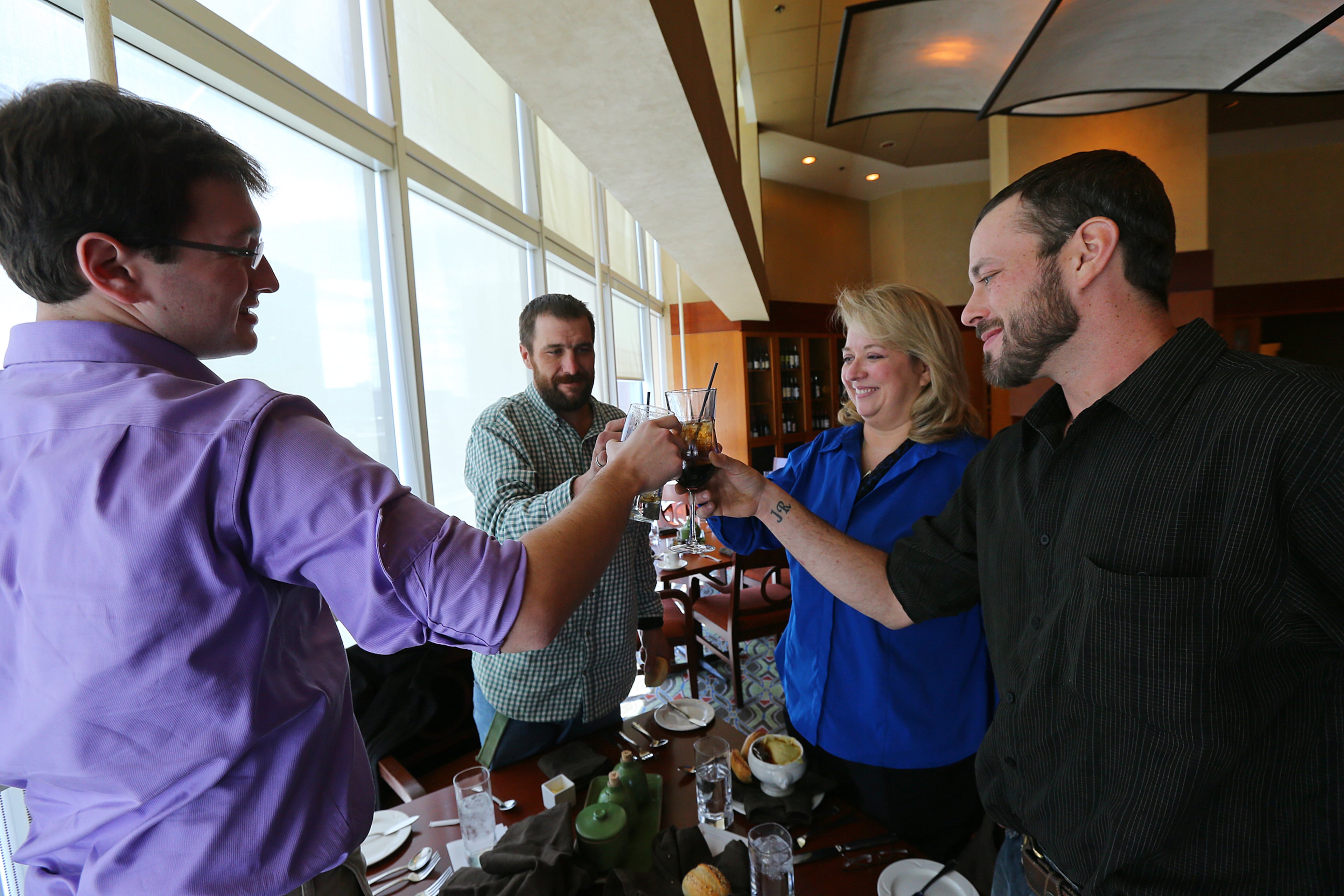 Andrew Rodecki proposes a toast to his brother Joel Hartman, Hartman's stepmother Deanna Rodecki, and brother Erick Hordos to begin a Thanksgiving Day reunion meal at the Omni Hotel at CNN Center on Thursday, Nov. 28, 2013, in Atlanta. It is the first time the three brothers have sat down together for a Thanksgiving meal. Andrew Rodecki said, "I propose a toast to long lost family coming together and many, many years of knowing each other and getting along to come."