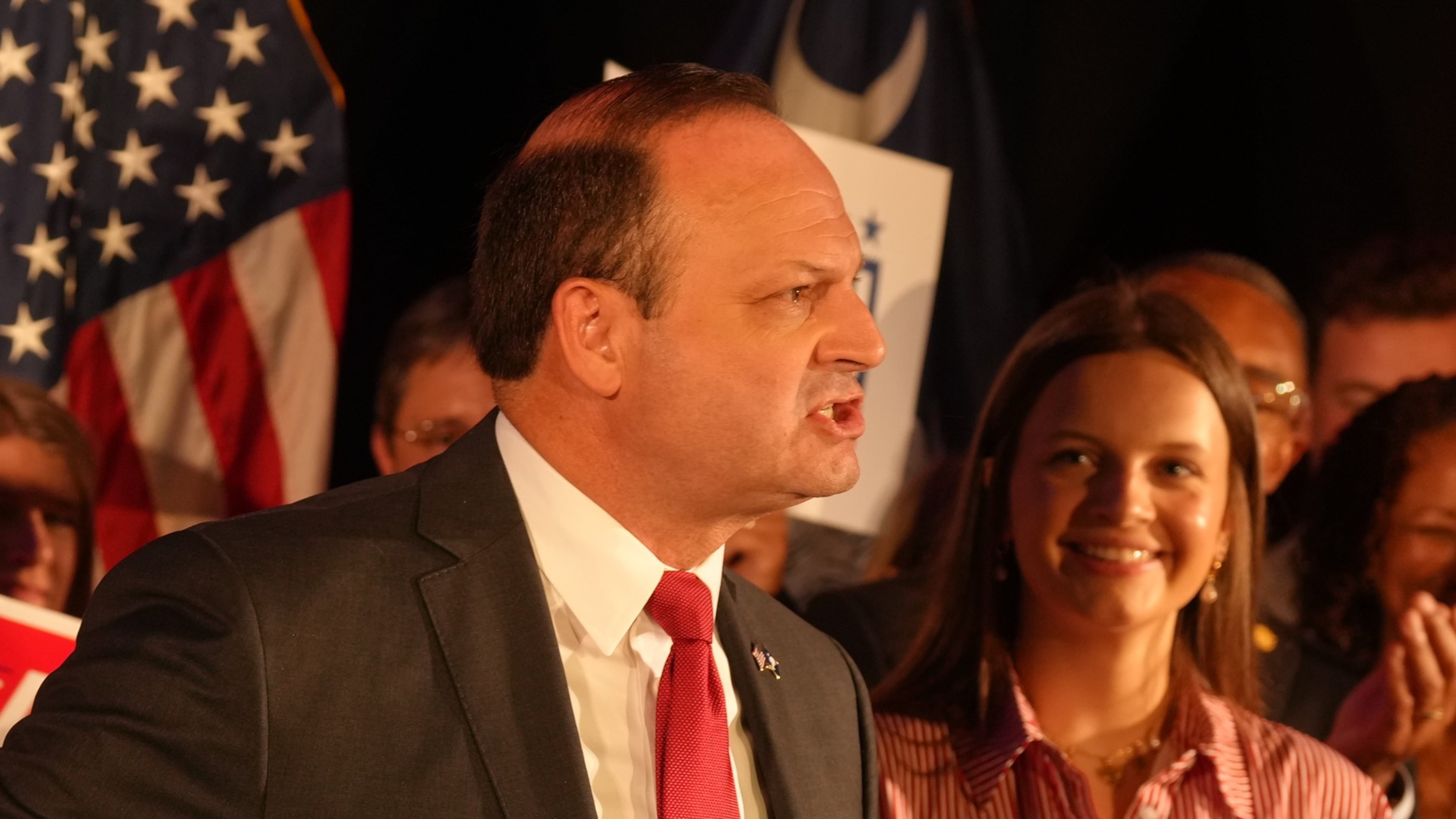 As his daughter, Anna Grace, looks on, South Carolina Attorney General Alan Wilson, left, speaks to supporters as he celebrates his GOP gubernatorial runoff victory in a hotel ballroom on Tuesday, June 23, 2026, in Columbia, S.C. (AP Photo/Meg Kinnard)