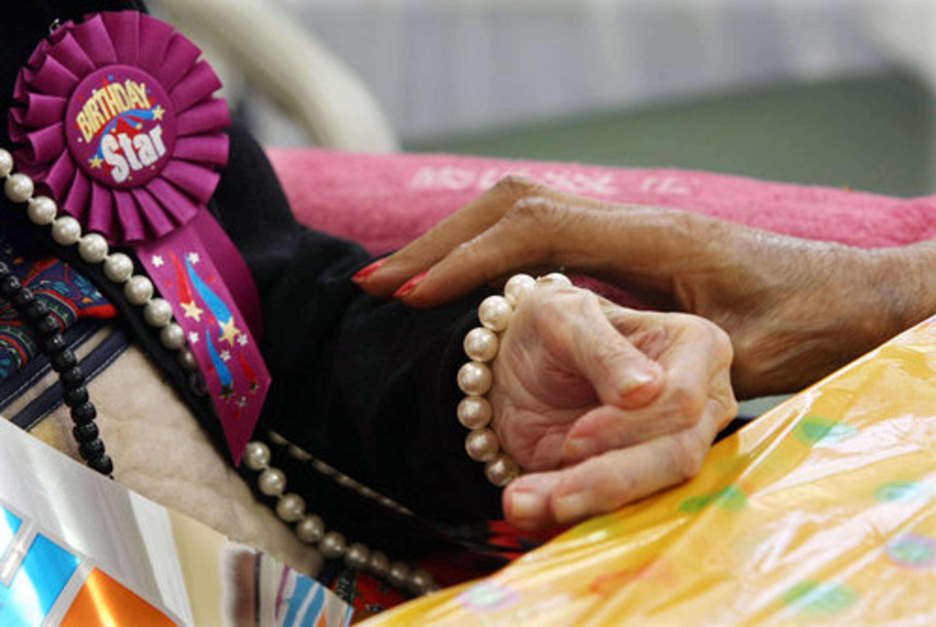 Frances Clark, 81, holds the hand of her friend Besse Cooper as Cooper celebrates her 113th birthday.