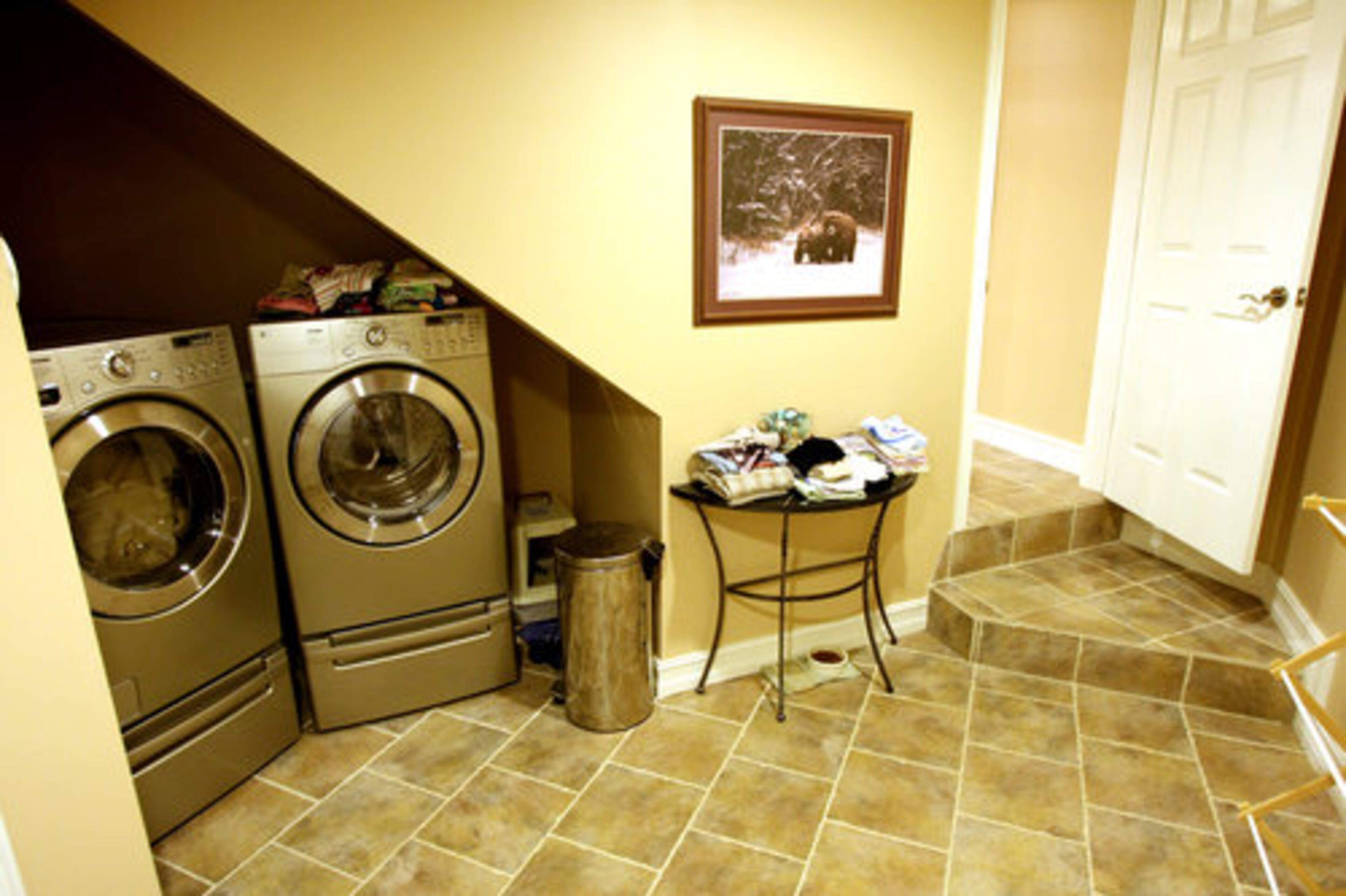 The laundry room seems more spacious by putting the washer and dryer against a recessed wall.