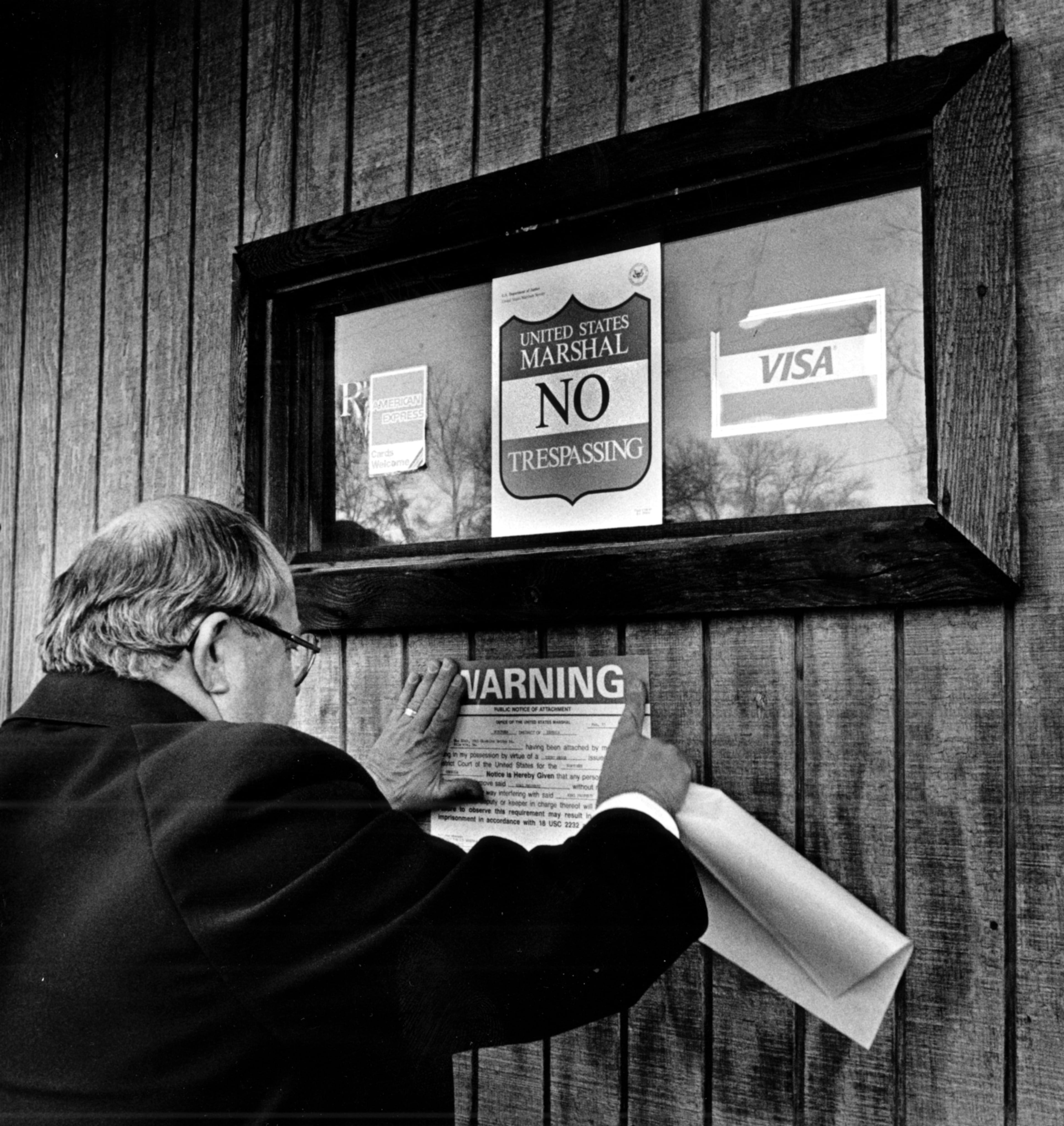 Feb. 13, 1985 - Atlanta, Ga.: - Deputy Marshal William Floyd posts warning signs on the She Club on Cheshire Bridge Road.