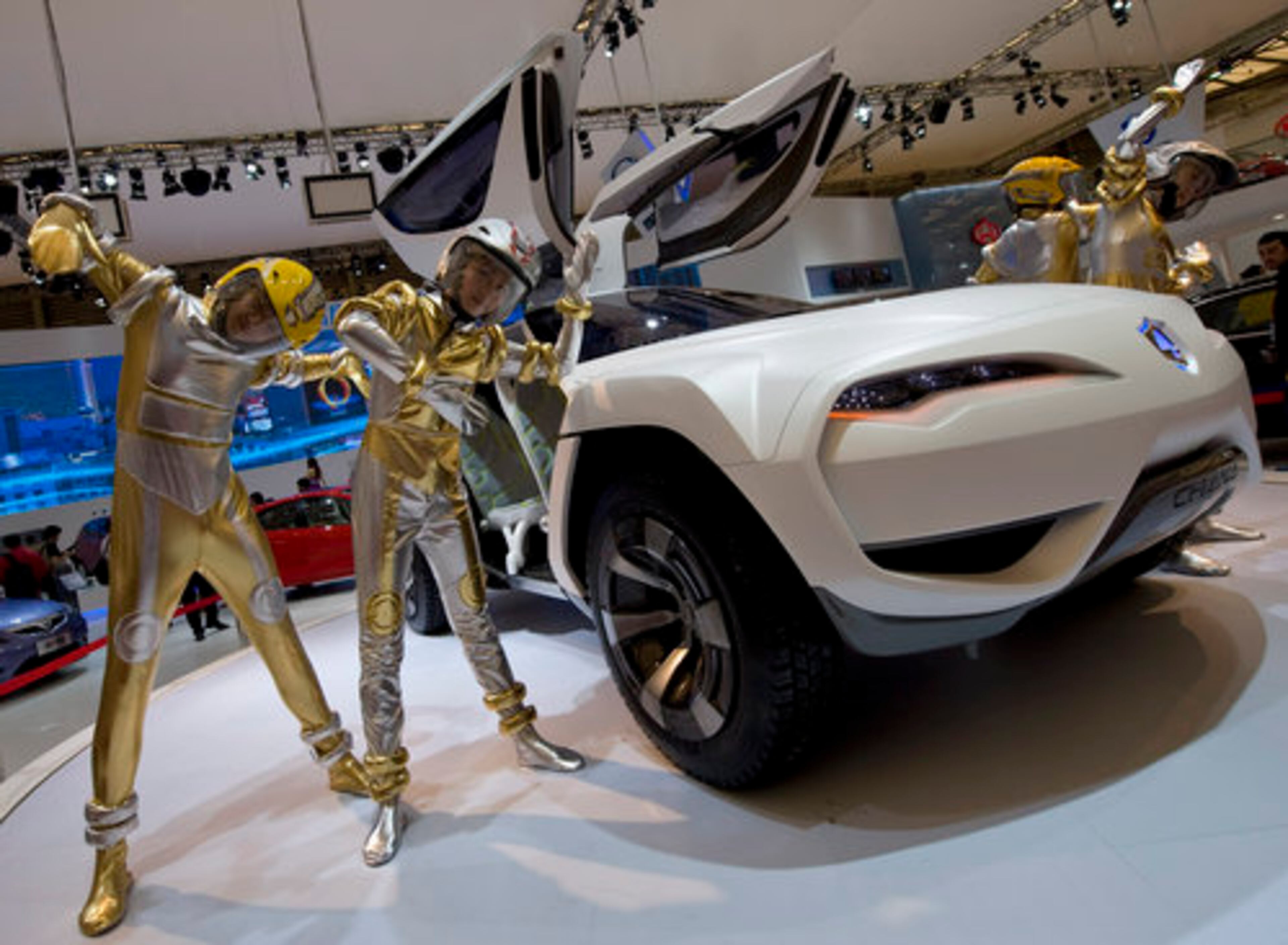 Chinese dancers perform next to a Chana E301 concept car on display.