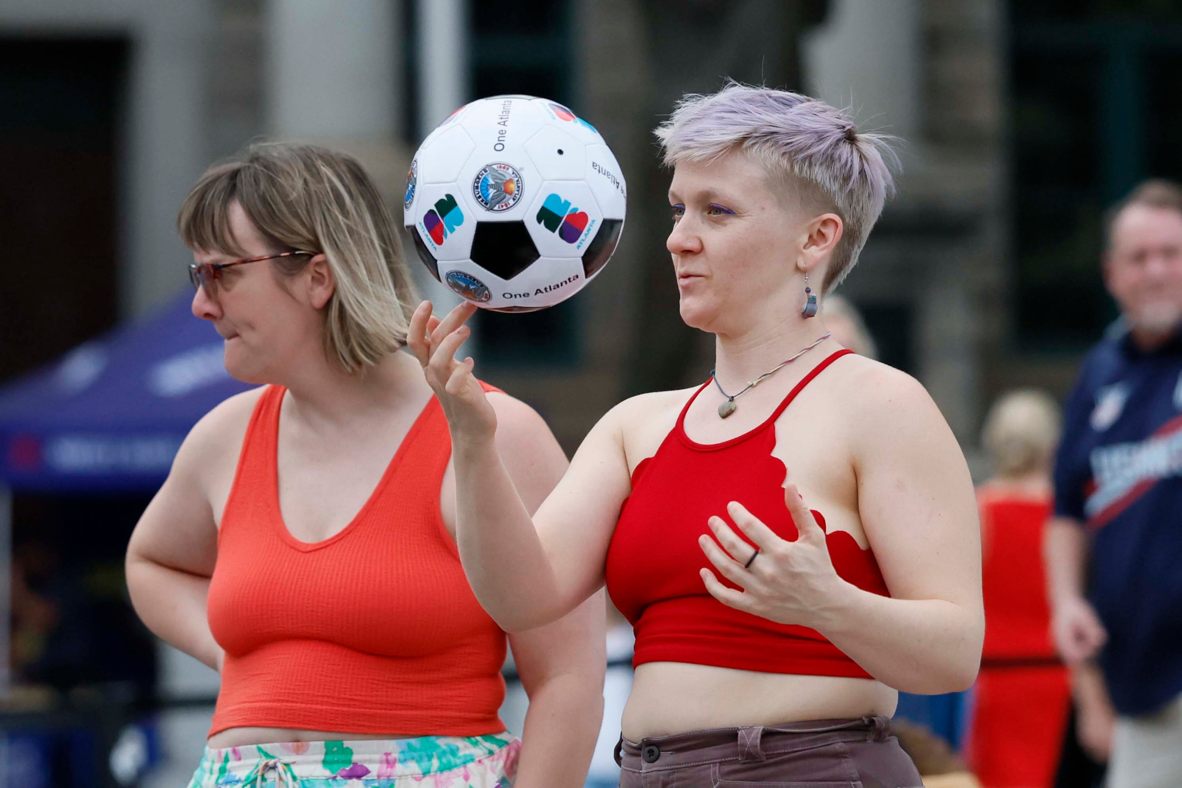 Alicia Bogart (right) plays with a soccer ball while Mathilde Piard hangs out during the Decatur WatchFest ’26 music series on Thursday, June 25, 2026. (Miguel Martinez/AJC)