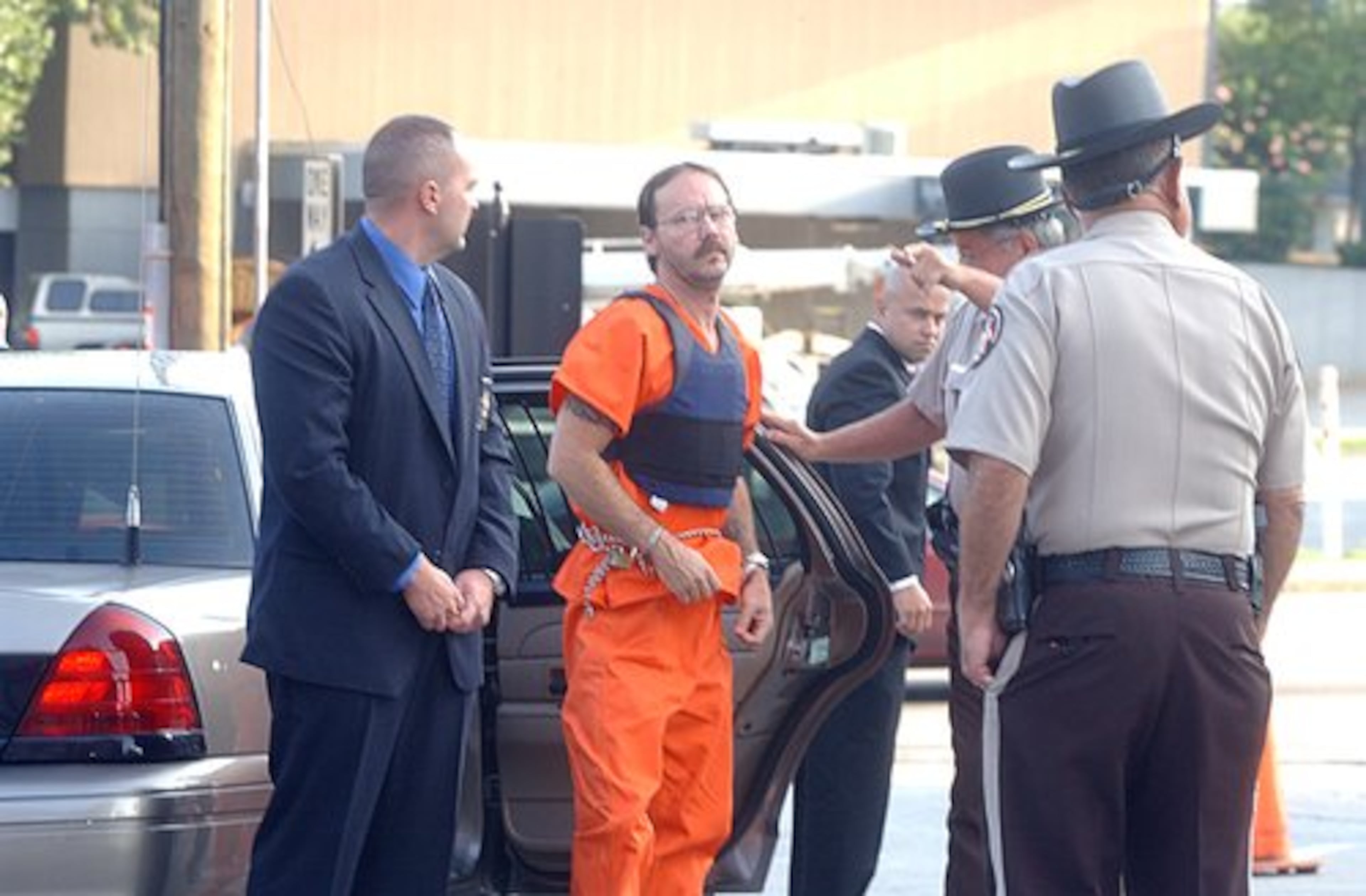 Michael William Ledford is led from a police car into Paulding County magistrate court on July 31, 2006, after being arrested in Ewing's murder.