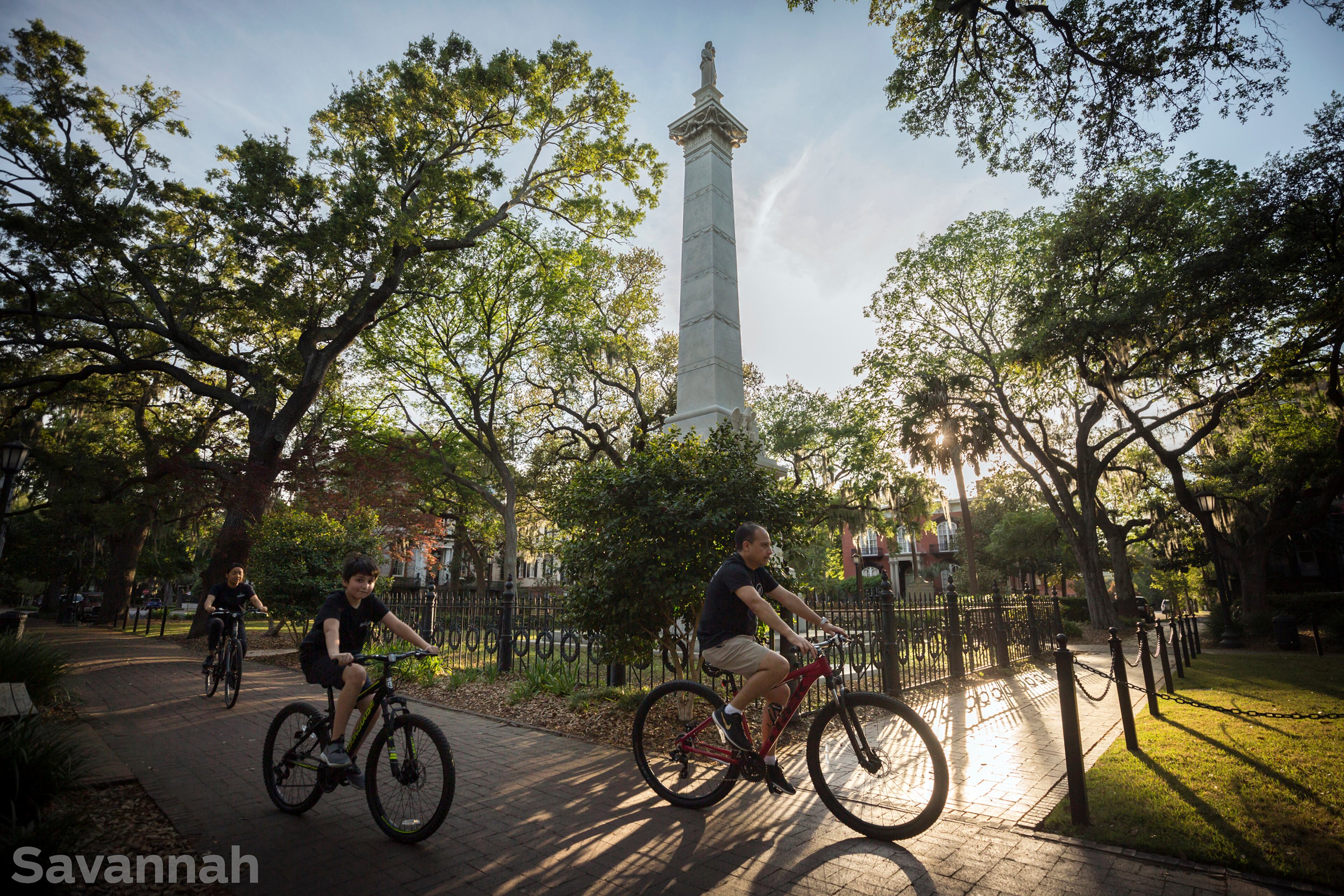 SAVANNAH, GA - APRIL 6, 2020: A family rides bikes through Monterey Square and the Pulaski monument in Savannah's Landmark Historic District. Monterey Square and the nearby Mercer House are popular tourist sites in Georgia's oldest city. (Stephen B. Morton for The Atlanta Journal-Constitution)
