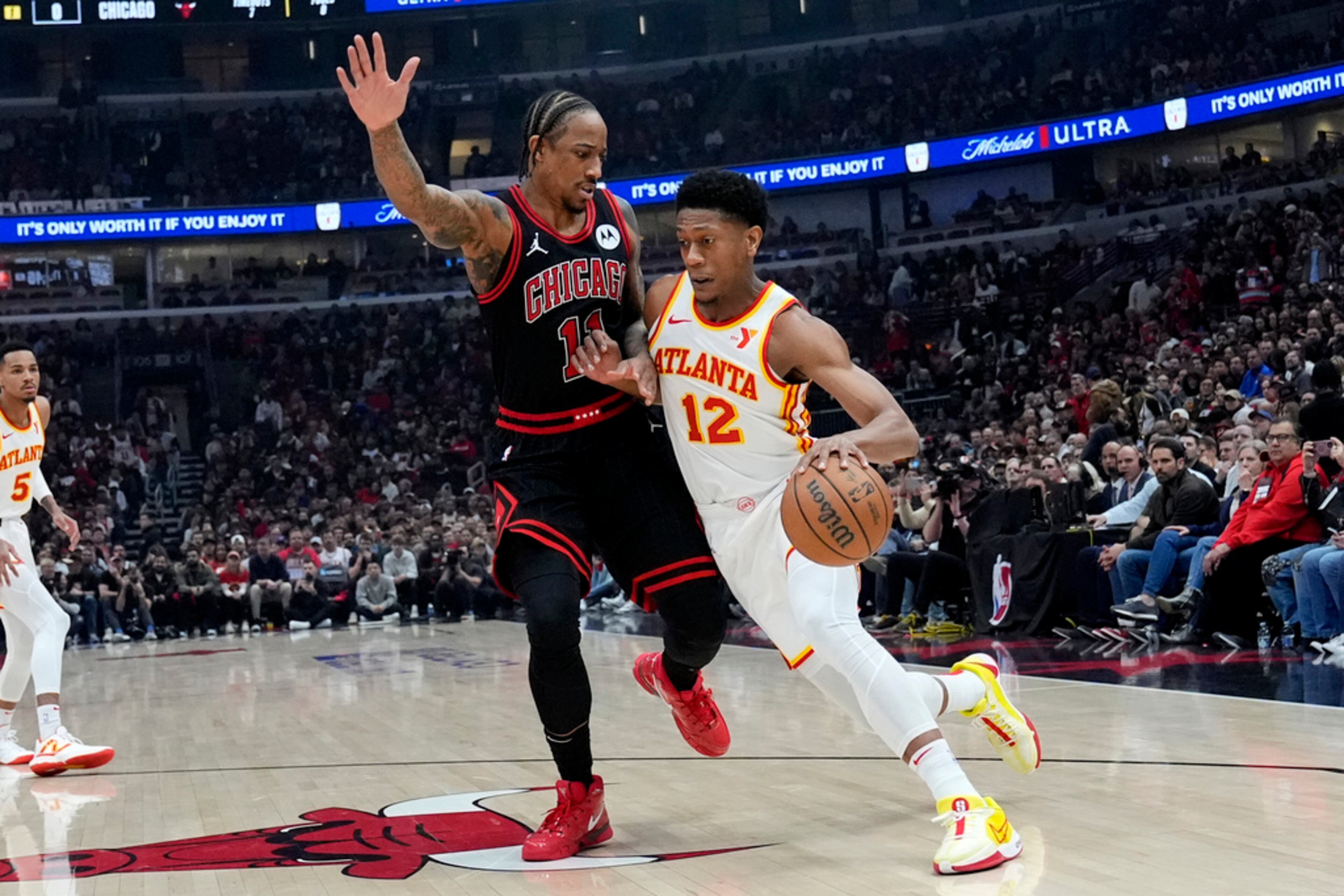 Atlanta Hawks forward De'Andre Hunter, right, drives as Chicago Bulls forward DeMar DeRozan guards during the first half of an NBA basketball play-in tournament game in Chicago, Wednesday, April 17, 2024. (AP Photo/Nam Y. Huh)