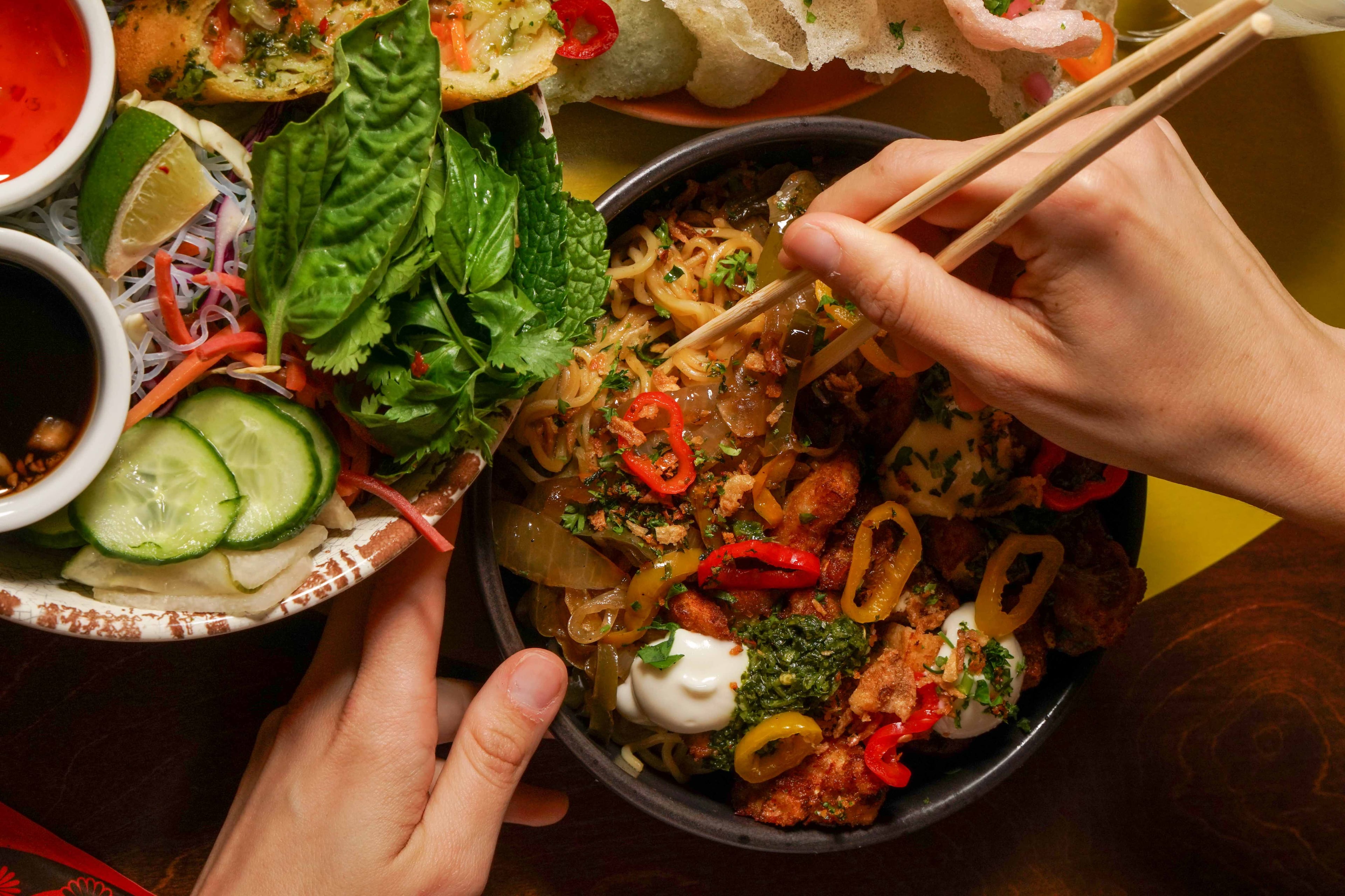 A bowl of vegan ramen chop suey (center) at Mushi Ni, with a vermicelli rice salad to the left. (Courtesy of Drew Perlmutter/Mushi Ni)