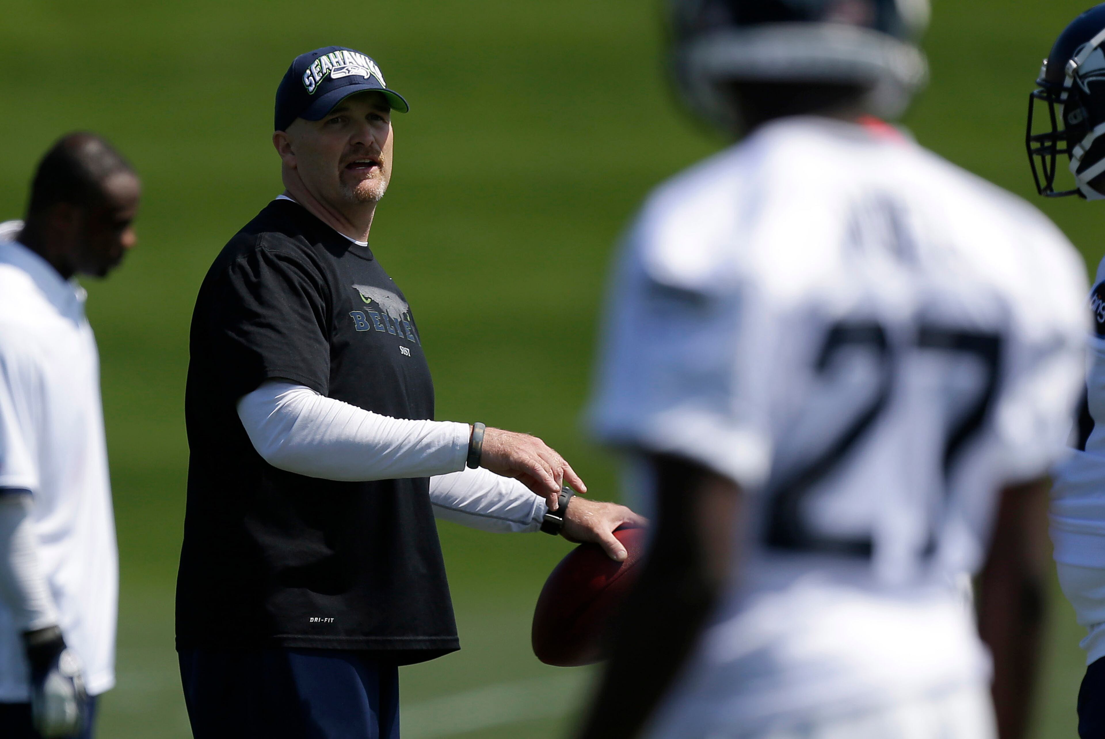 Dan Quinn, the Seattle Seahawks' new defensive coordinator holds a football as he talks to his players during practice drills at Seattle Seahawks NFL football Rookie Minicamp, Friday, May 10, 2013, in Renton, Wash. (AP Photo/Ted S. Warren)
