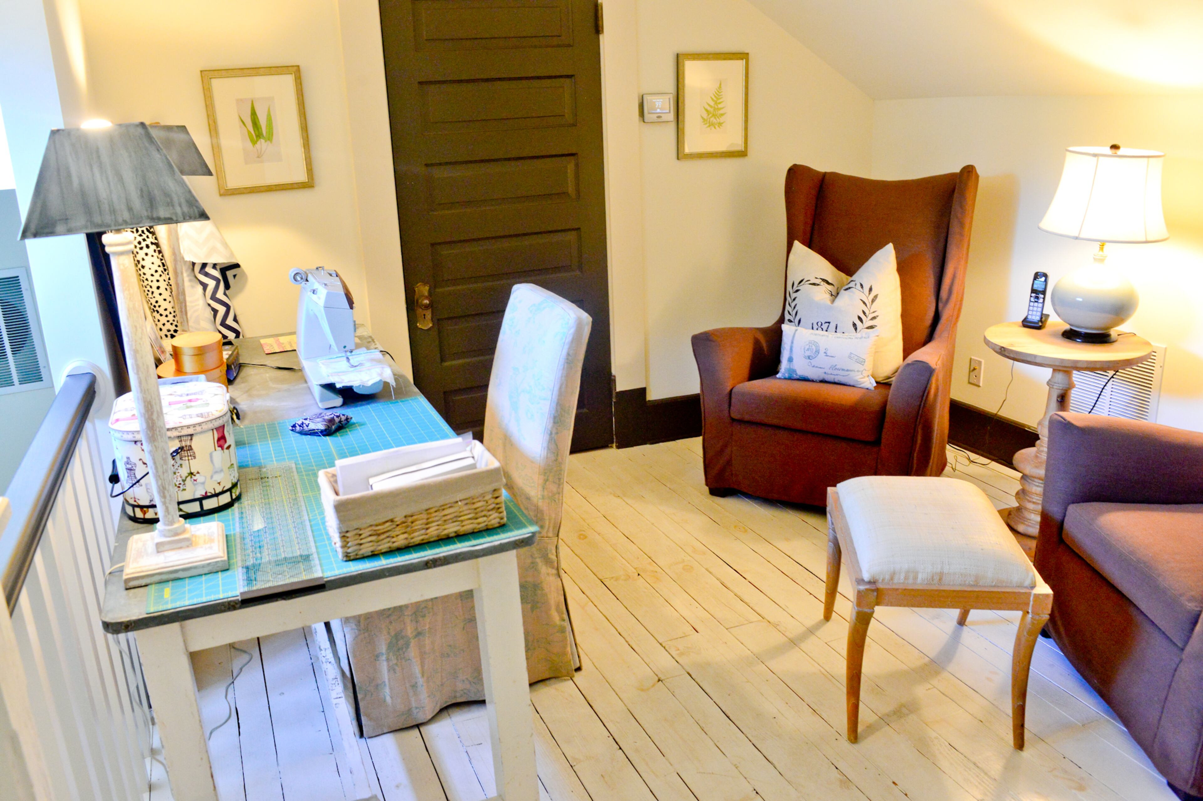 At the top of the stairs, in the formerly unfinished attic, Cole carved out a sitting area between the bedrooms that she uses as a sewing room. She chose stylish and functional furniture from Stanton Home Furnishings to create a comfortable workspace.