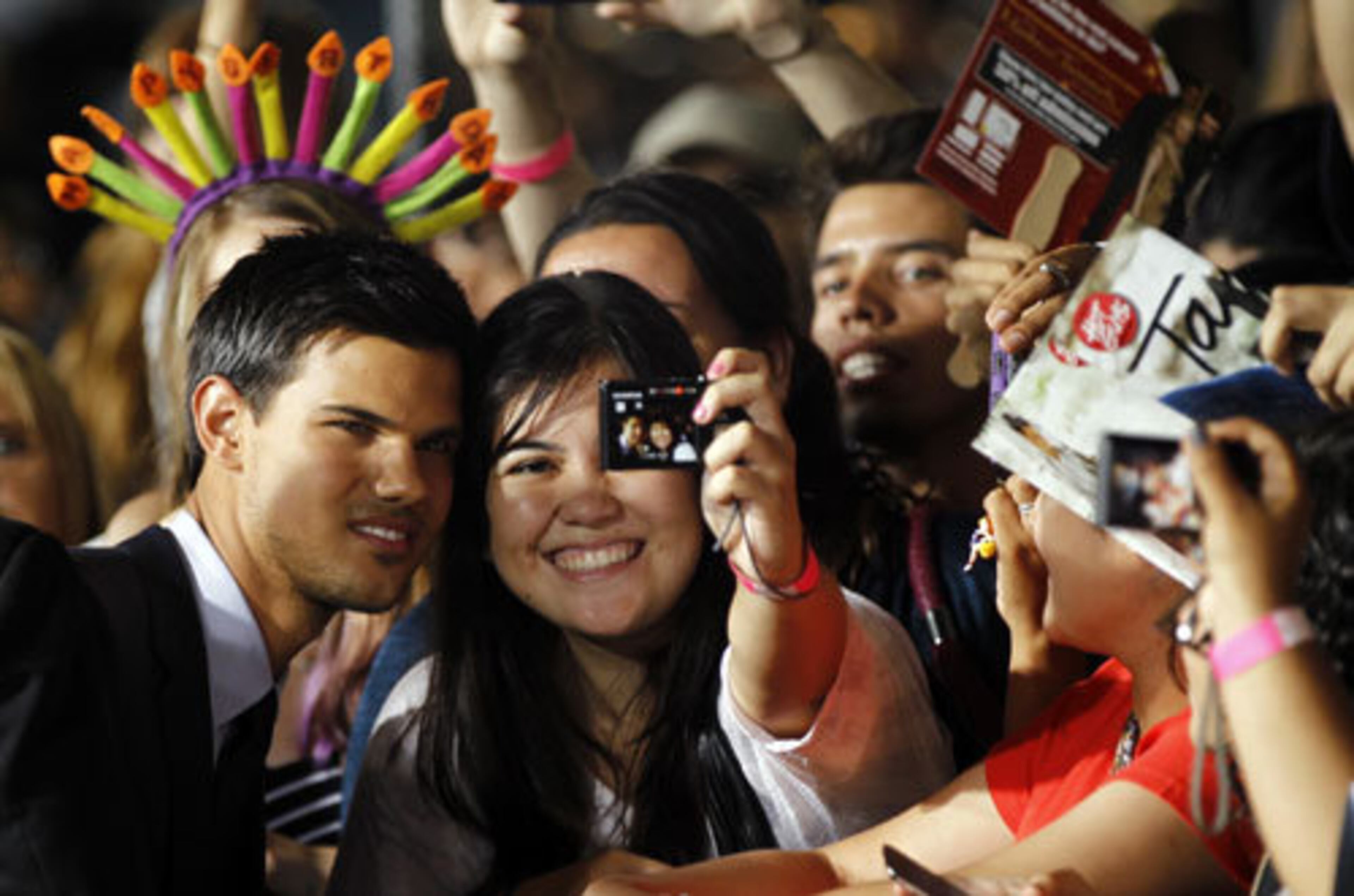 Taylor Lautner poses for a photo with a lucky fan as he arrives for the premiere of "Abduction." The thriller hits theaters nationwide Friday, Sept. 23.