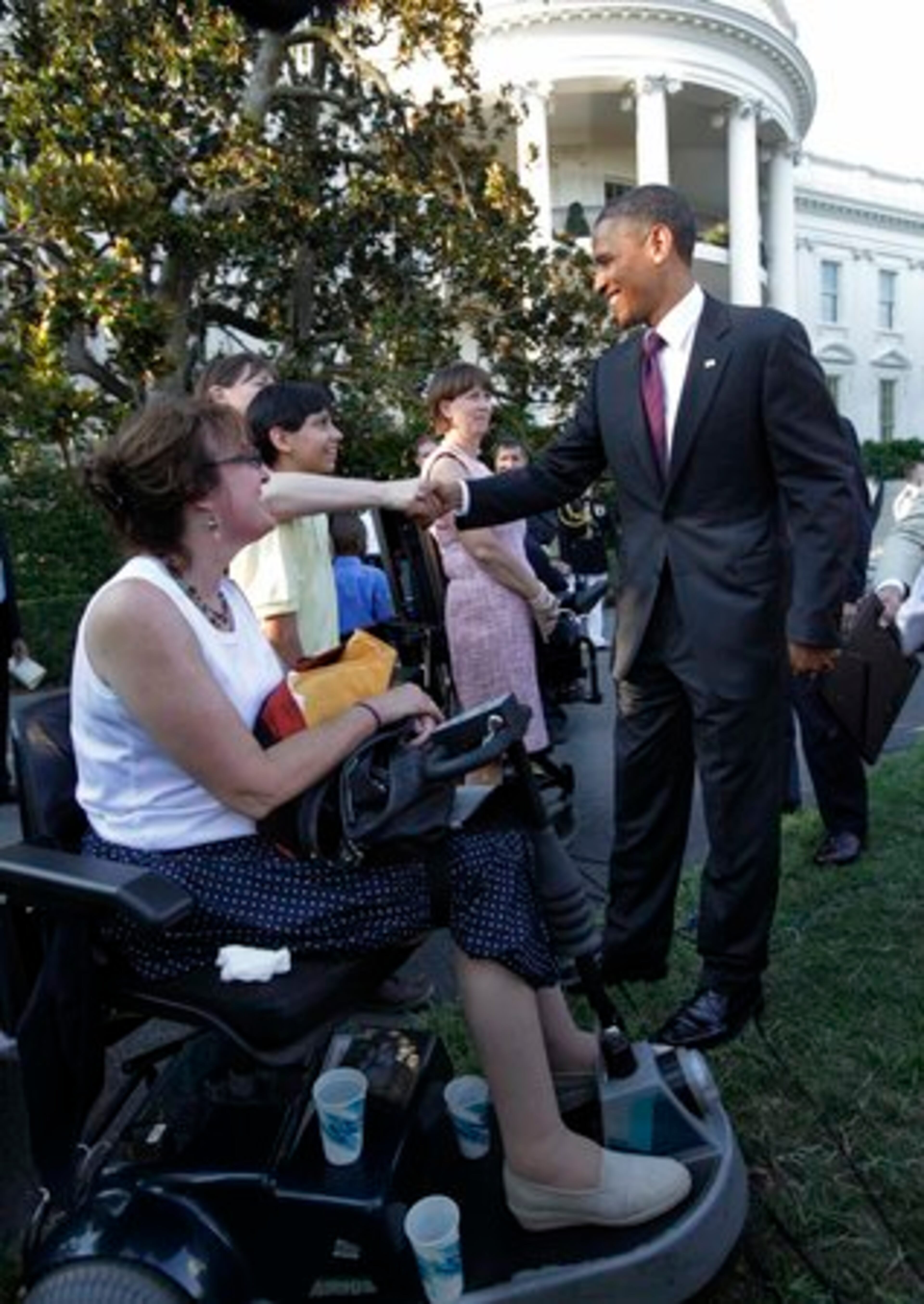 President Barack Obama greets guests attending a commemoration of the 20th anniversary of the Americans with Disabilities Act, the law designed to eliminate discrimination against people with disabilities and to make buildings more accessible by wheelchair, on the South Lawn of the White House.