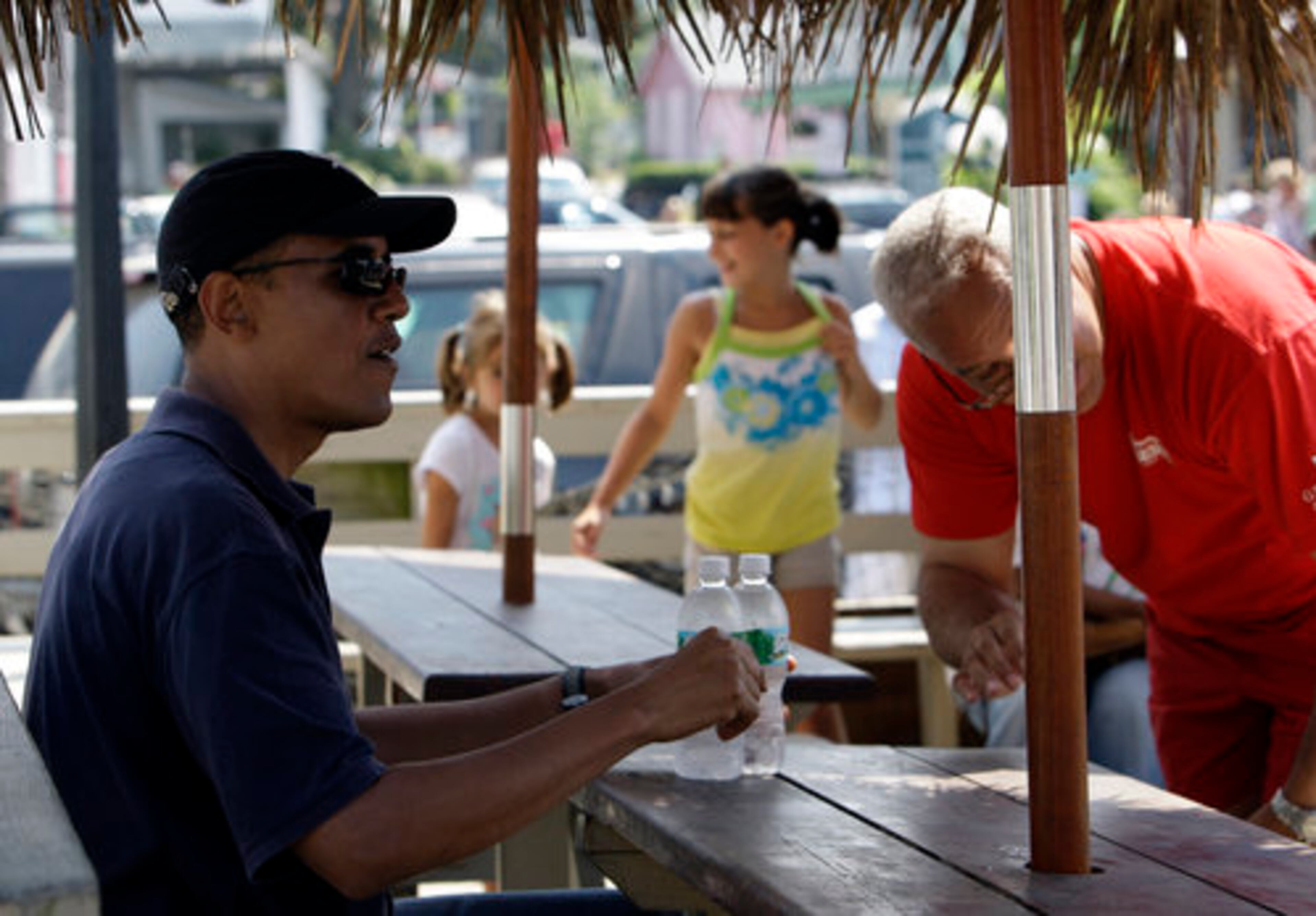 President Barack Obama takes his seat with friend, Dr. Eric Whitaker, as they wait for lunch at Nancy's.